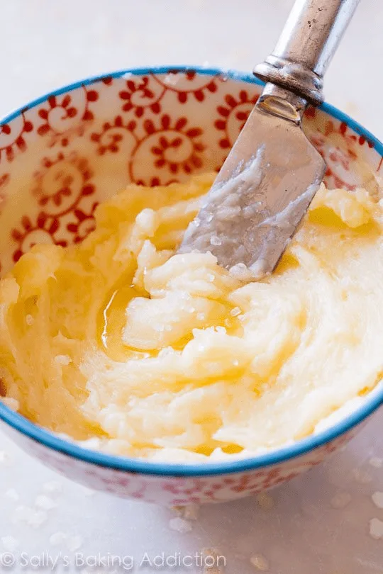 Honey butter mix in a red and white patterned bowl with a butter knife in the bowl. 