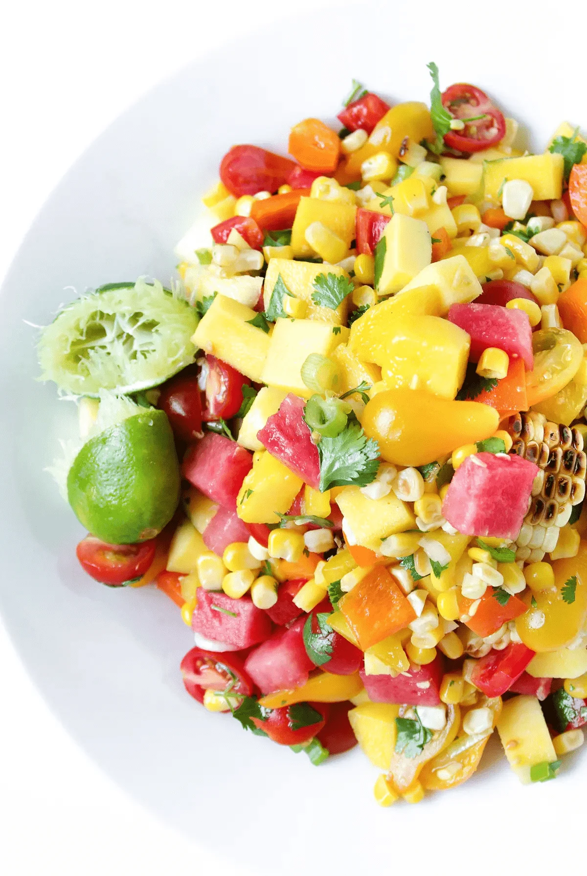 Watermelon Mango and Corn Salad in a white bowl.