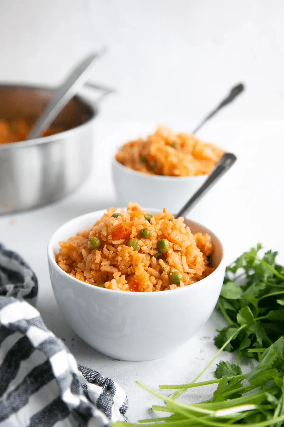 Mexican rice in white bowl with spoon in it. 