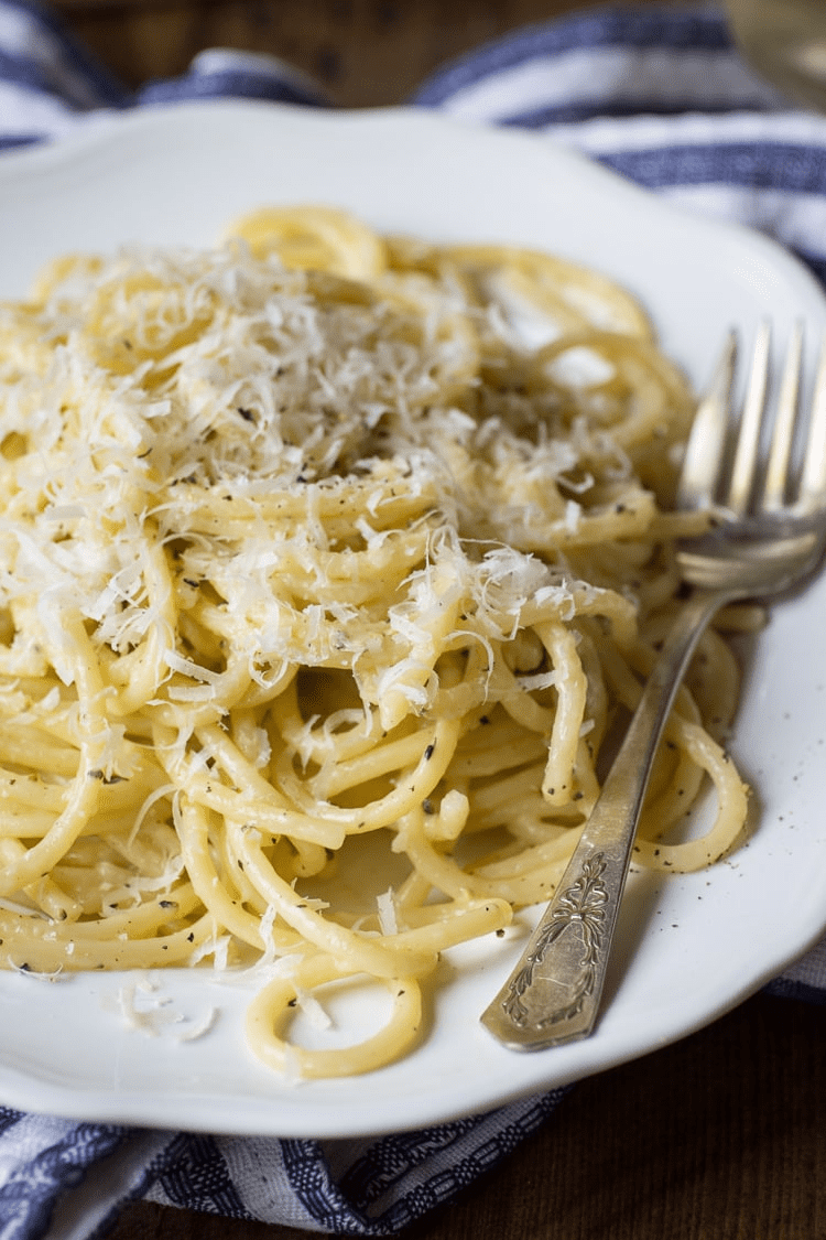 plate of spaghetti with shaved cheese on top