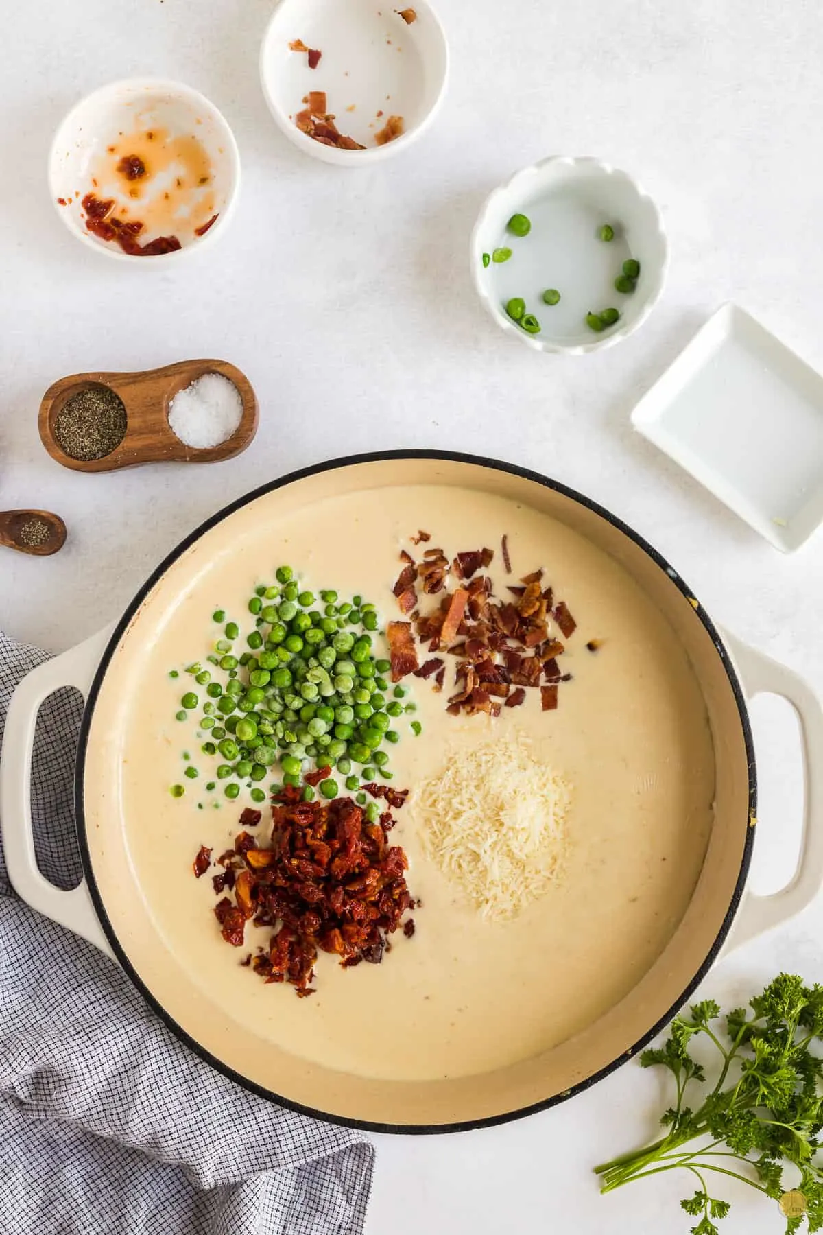 pan of sauce with peas and bacon in it