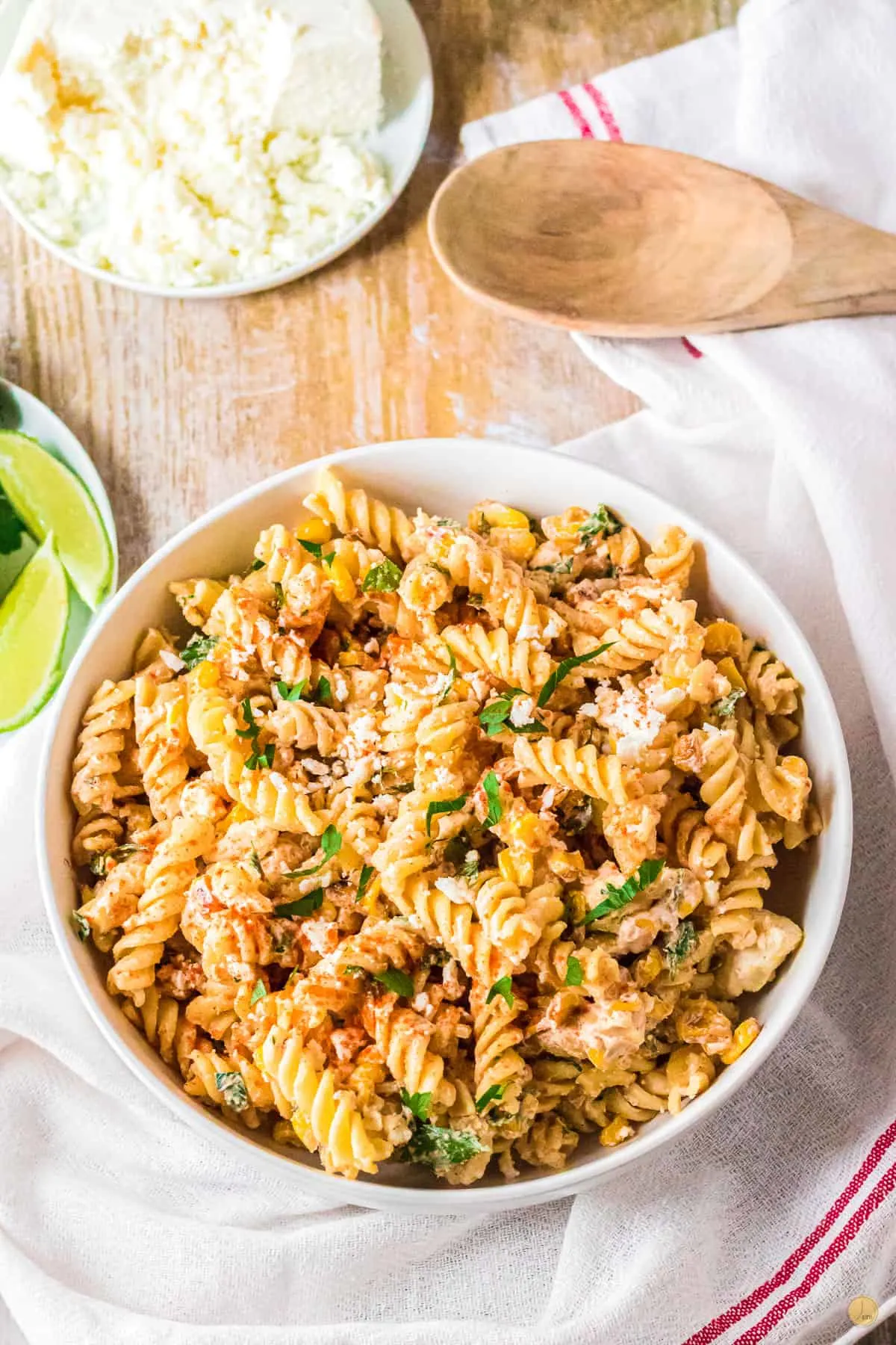 bowl of street corn pasta salad in a white bowl on a white napkin