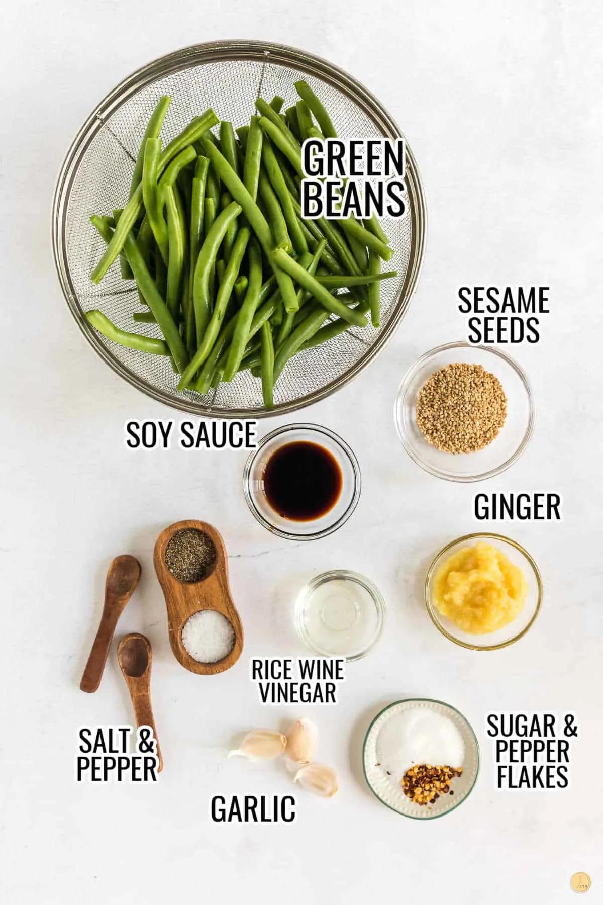 Ingredients for PF Changs Spicy Green Beans in small bowls including fresh green beans, kosher salt, toasted sesame seeds, soy sauce, grated ginger, finely minced garlic, rice wine vinegar, sugar, black pepper, and crushed red pepper flakes.