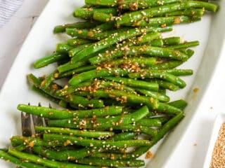 White oval plate filled with Spicy green beans.