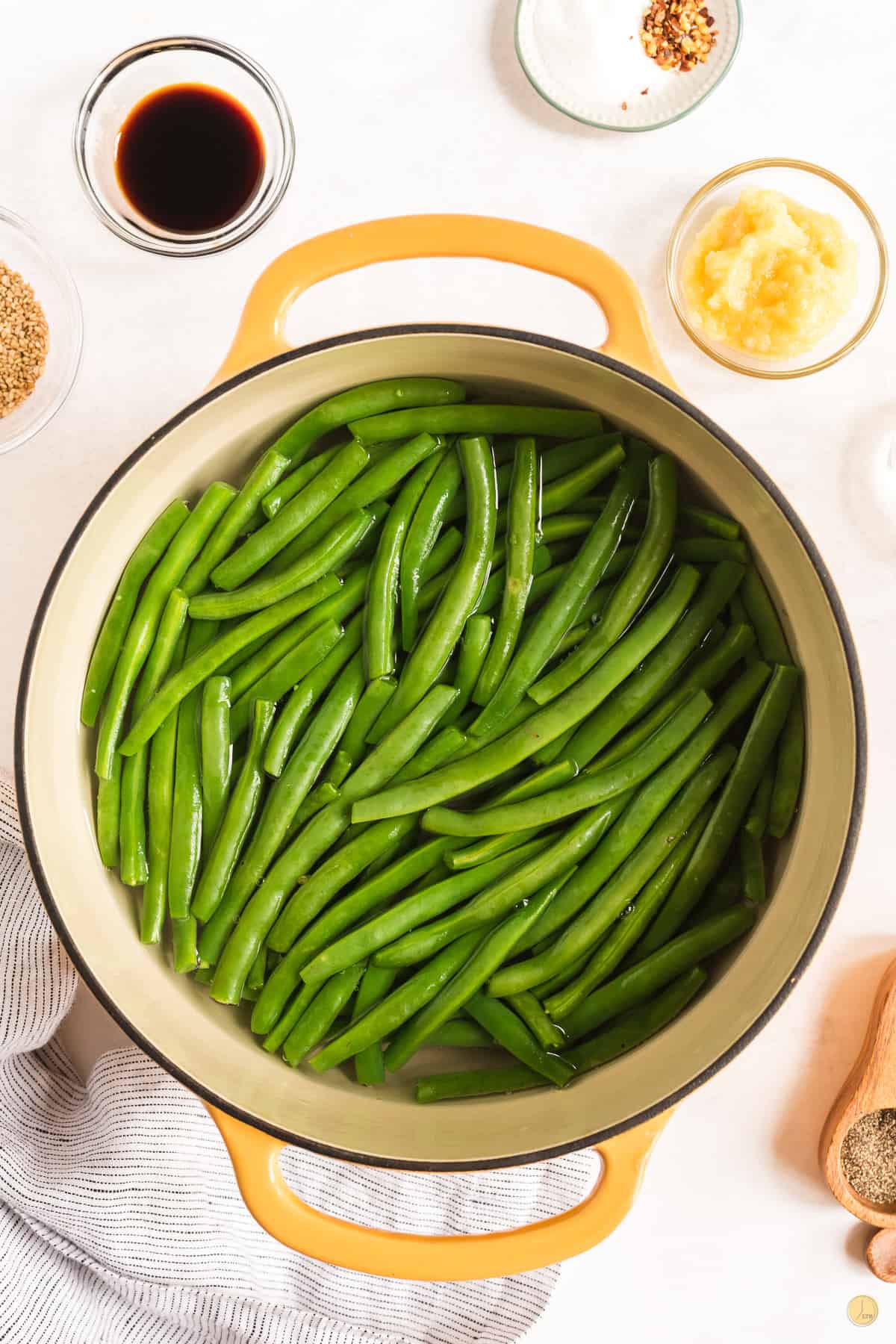 Top view of a dutch oven with green beans in water. 