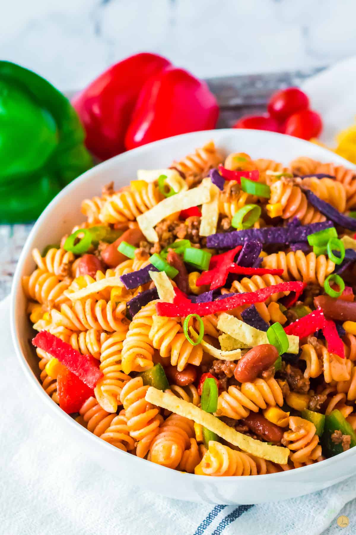 bowl of taco pasta salad with bell peppers in the background