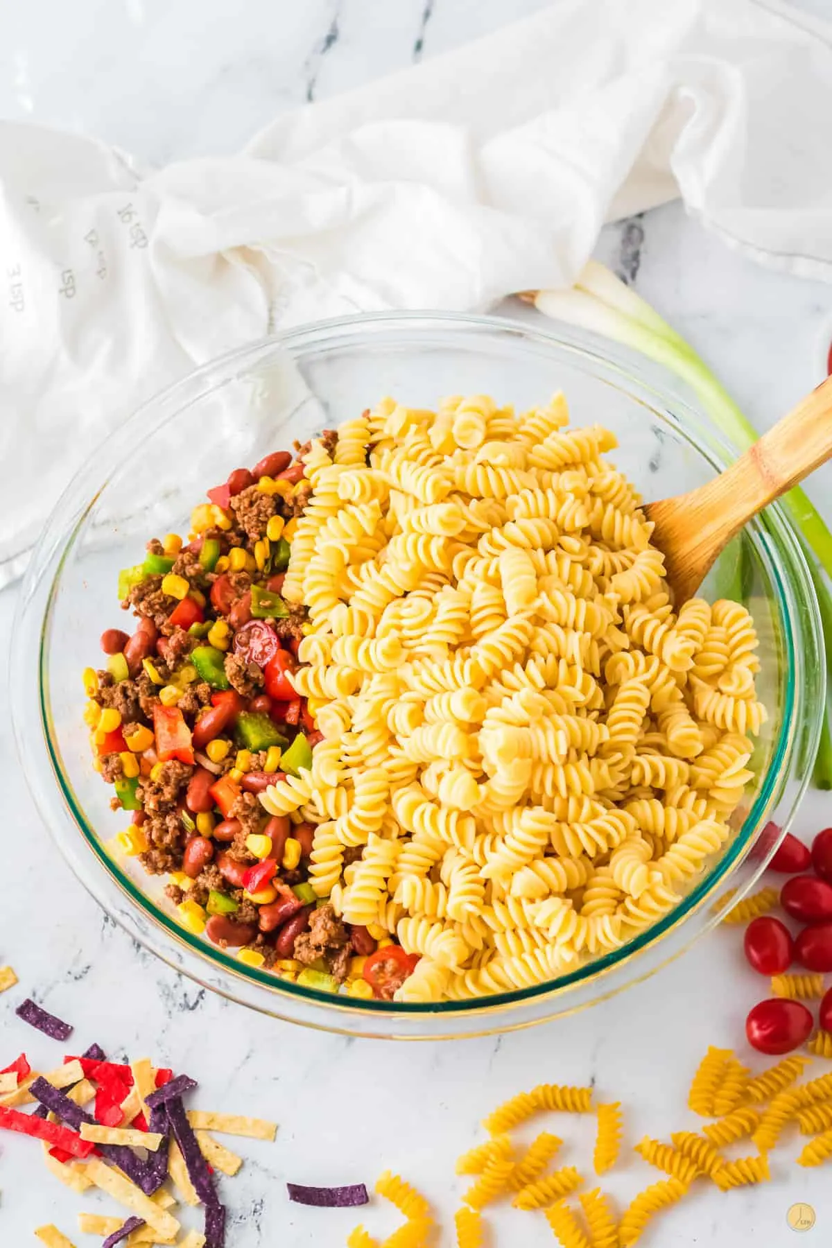 bowl of rotini pasta with ground beef and a spatula