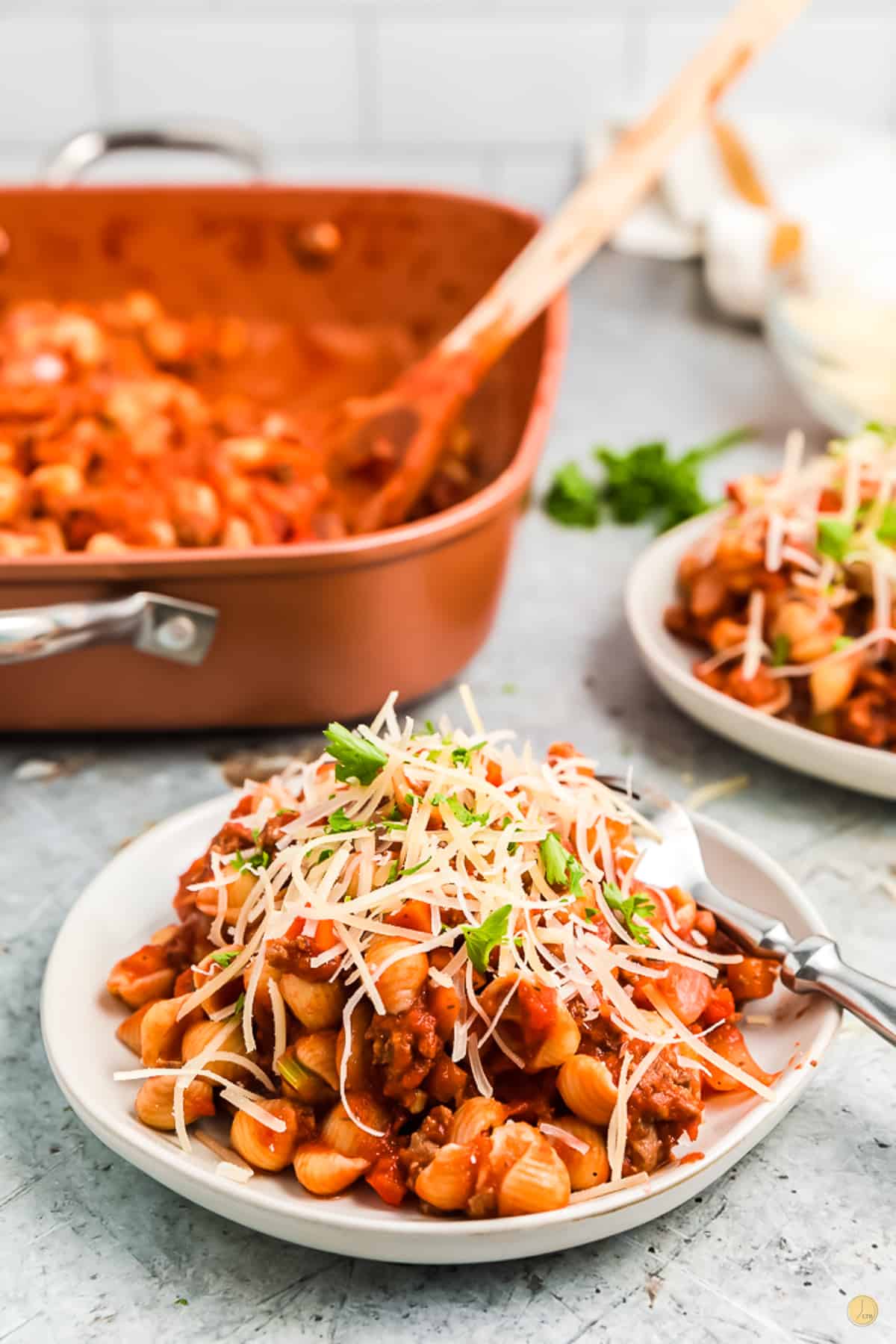 beefaroni on a white plate covered with shredded cheese