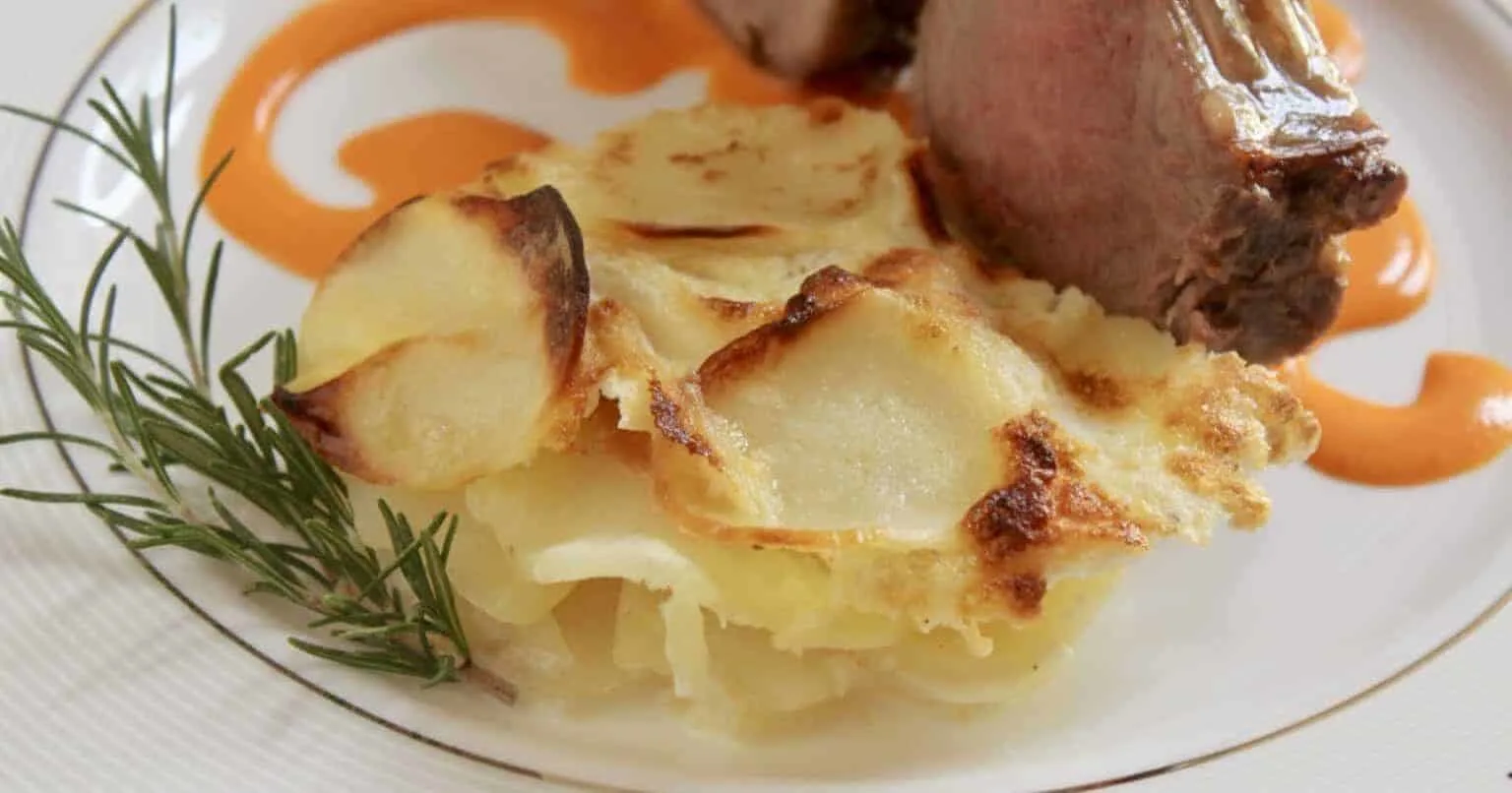 gratin dauphinois potatoes on a plate with sage