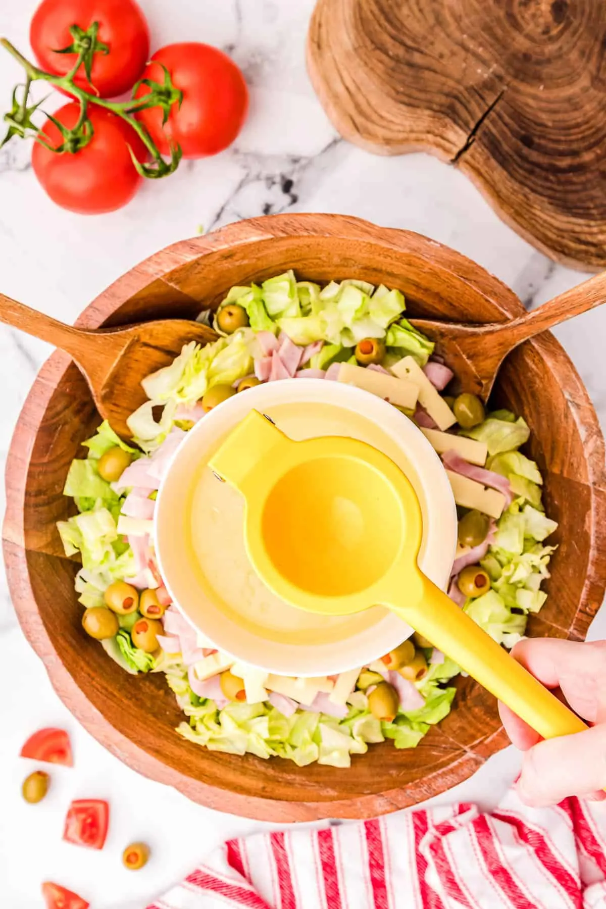 dressing bring mixed over a bowl of lettuce