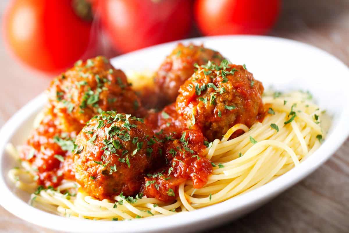 spaghetti and meatballs on a white plate