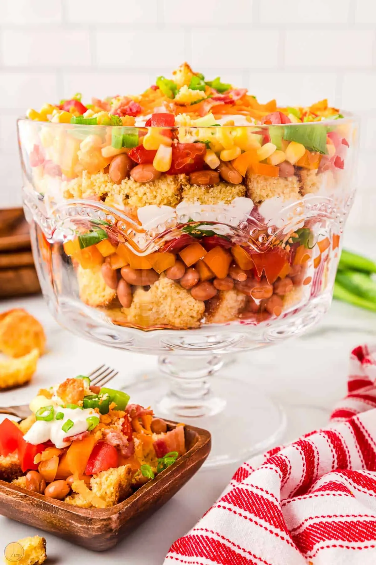 clear trifle bowl with layered salad in it
