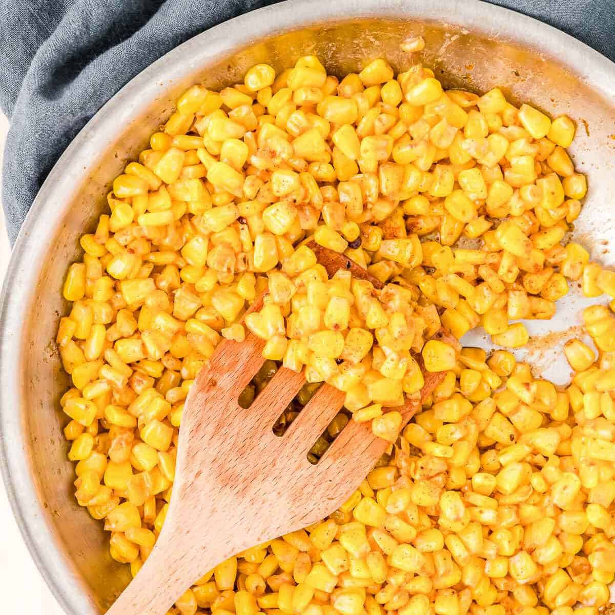 fried corn in a skillet with some swiped from center of skillet