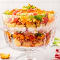 clear trifle bowl with layered salad in it