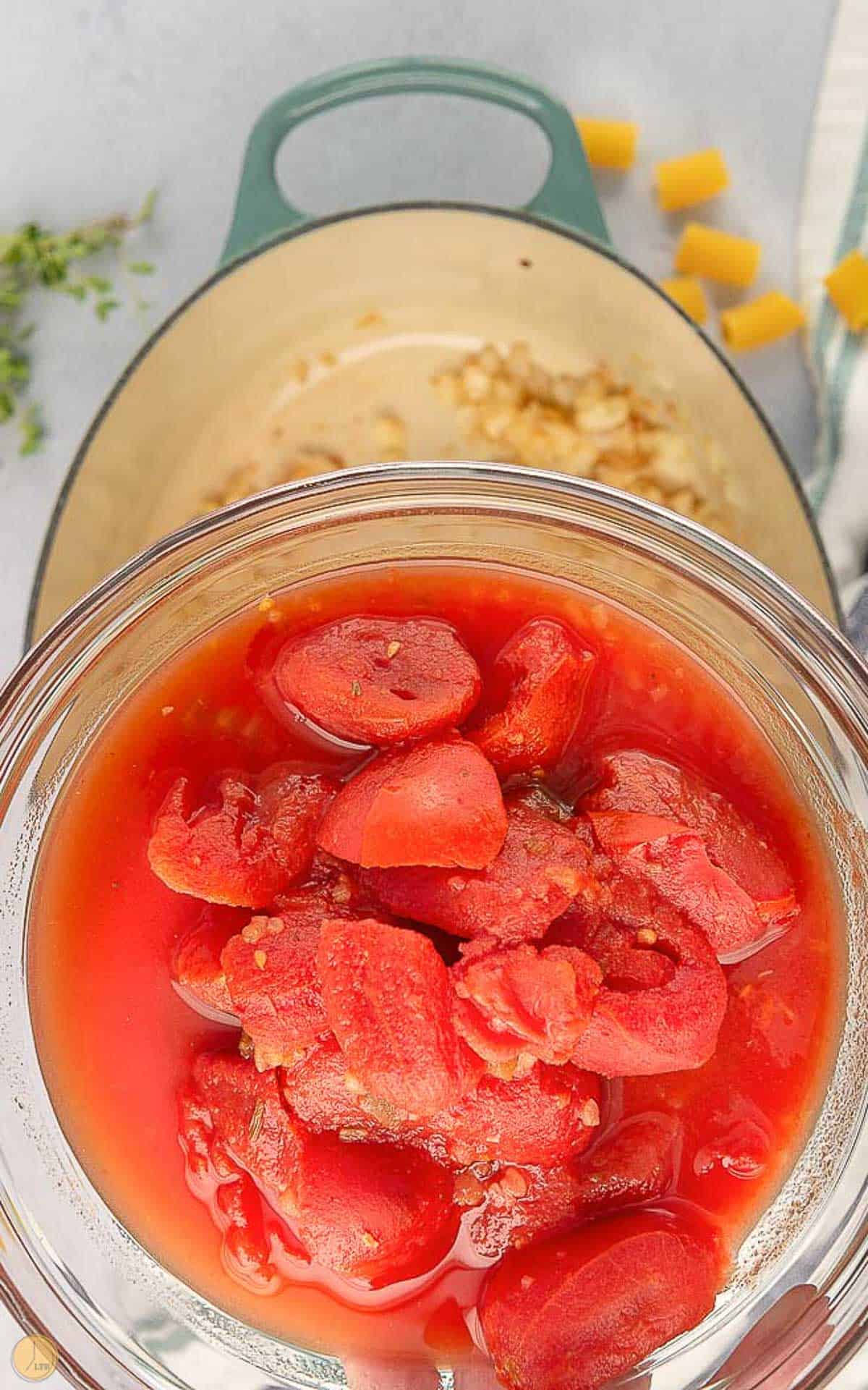 tomatoes being poured into a pot