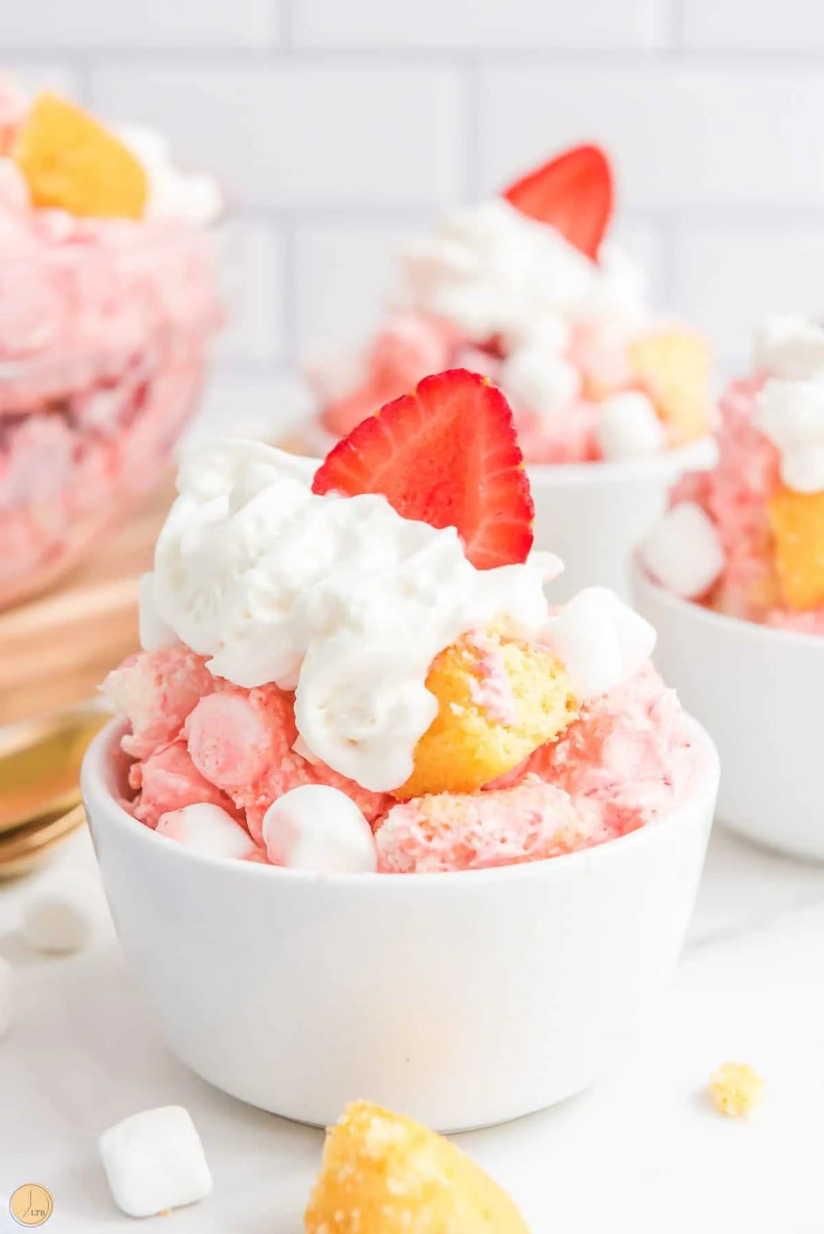 single bowl of fluff salad topped with whipped cream and a fresh strawberry
