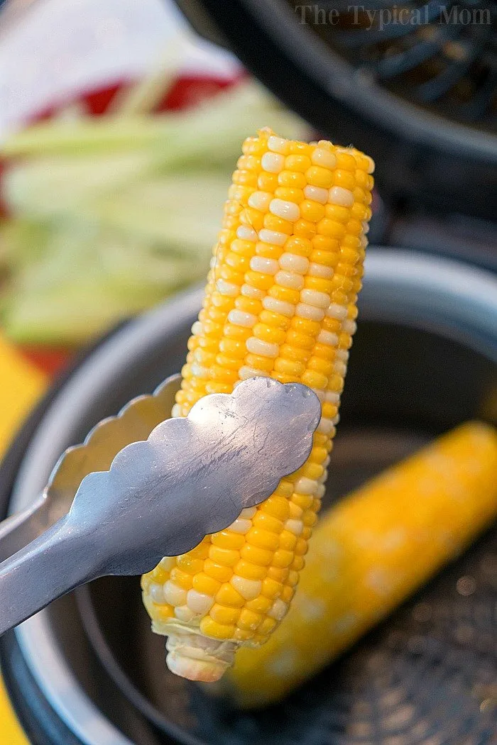 tongs holding an ear of corn