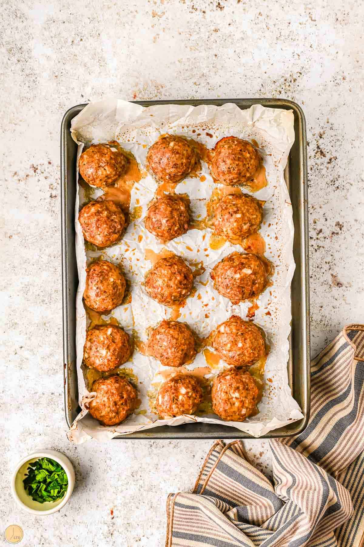 baked italian meatballs on a baking sheet with parchment paper