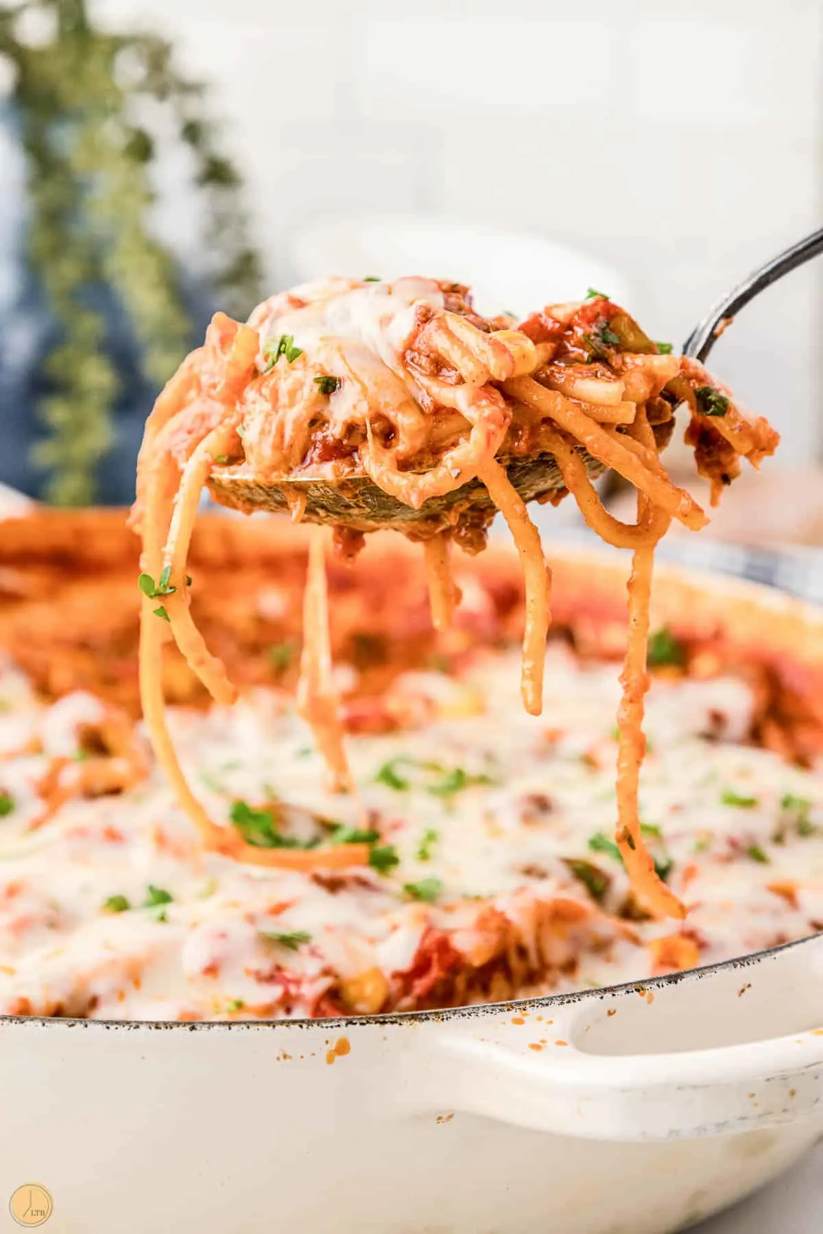 spoon scooping pasta out of a skillet