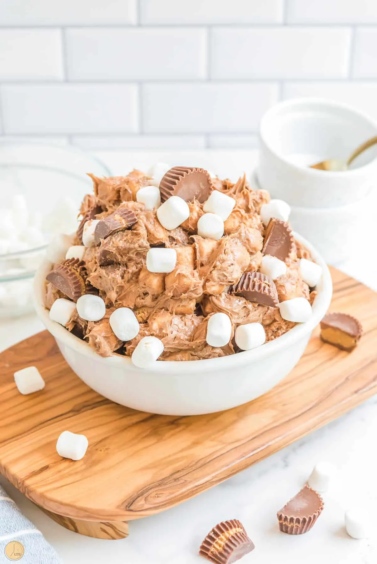 bowl of peanut butter fluff in a white bowl on a wood platter