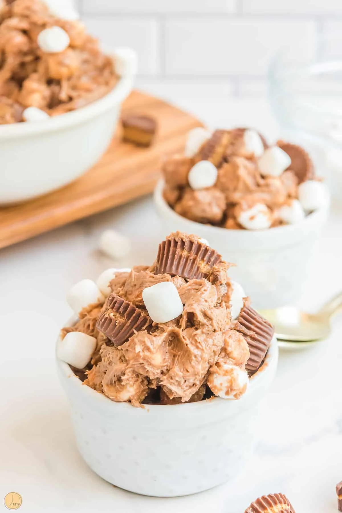 two bowls of fluff salad topped with peanut butter cups and mini marshmallows