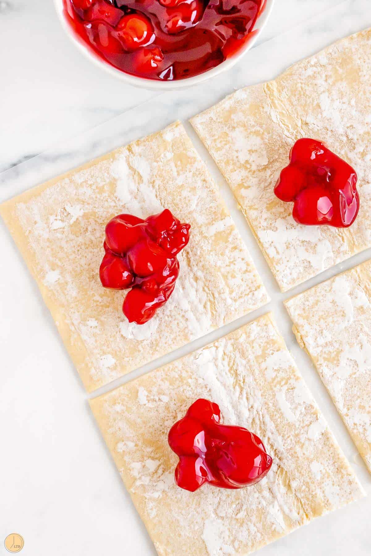 cherry pie filling on puff pastry squares