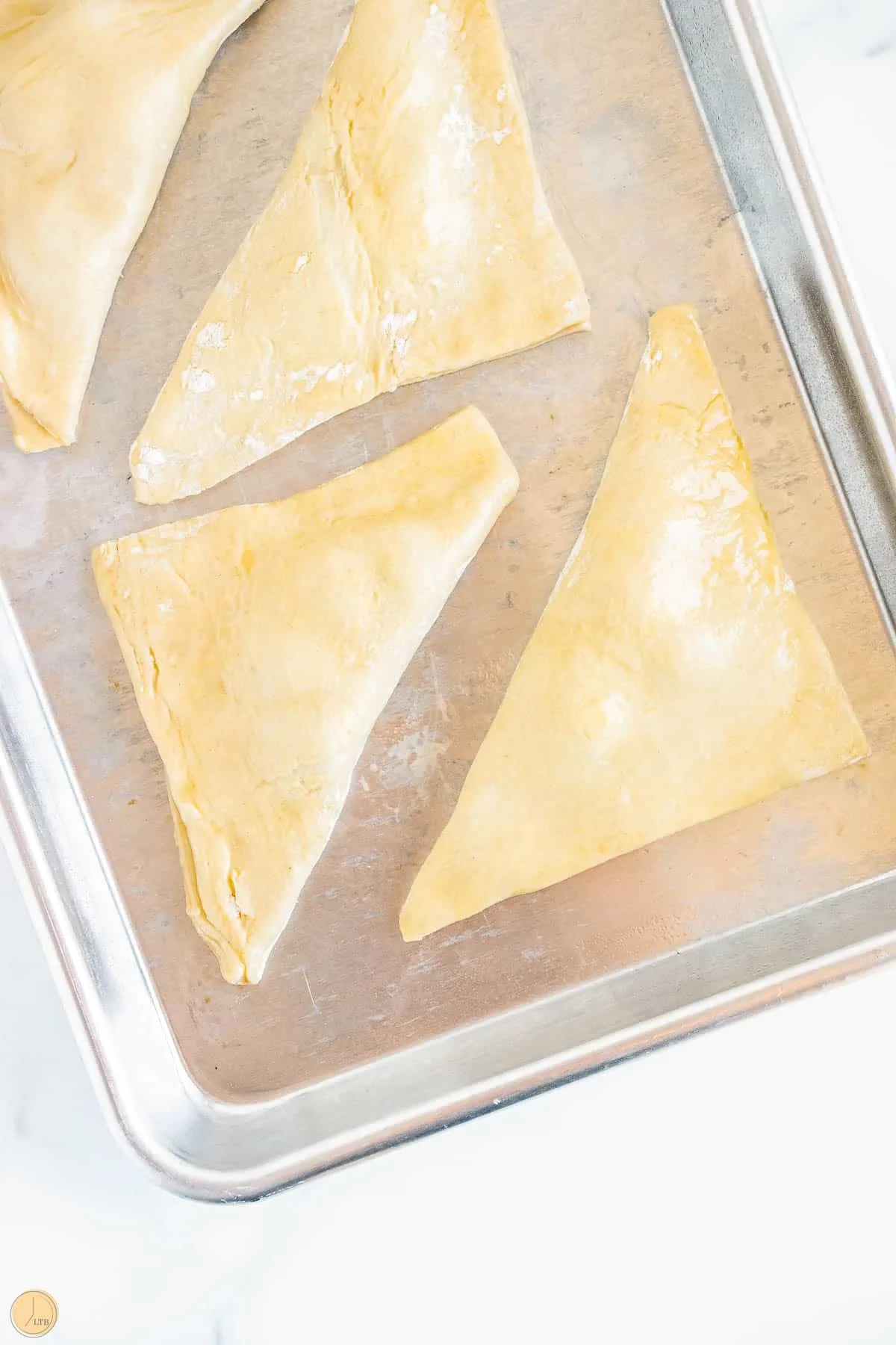 unbaked turnovers on a metal sheet pan