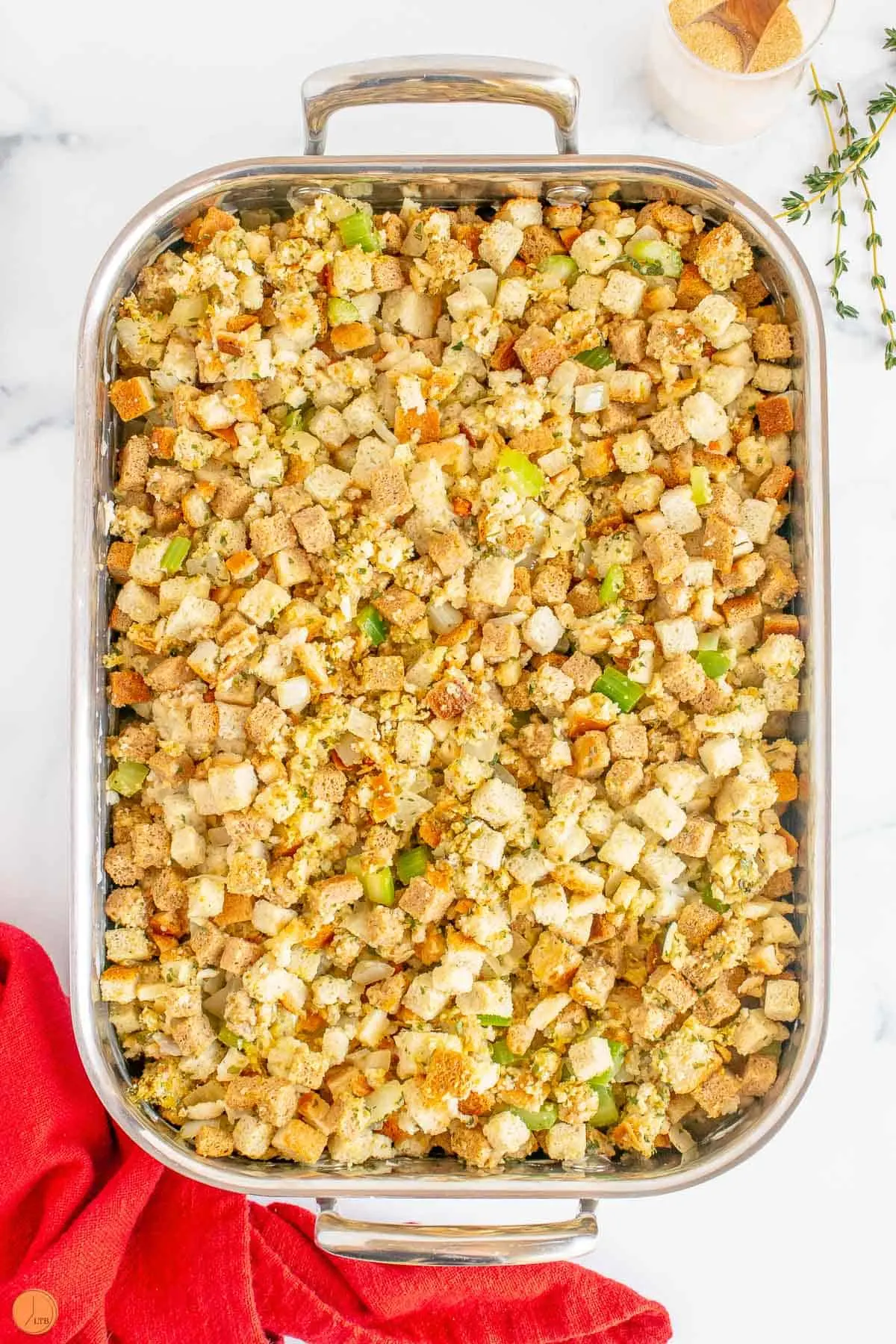 silver stuffing casserole pan with unbaked dressing in it.
