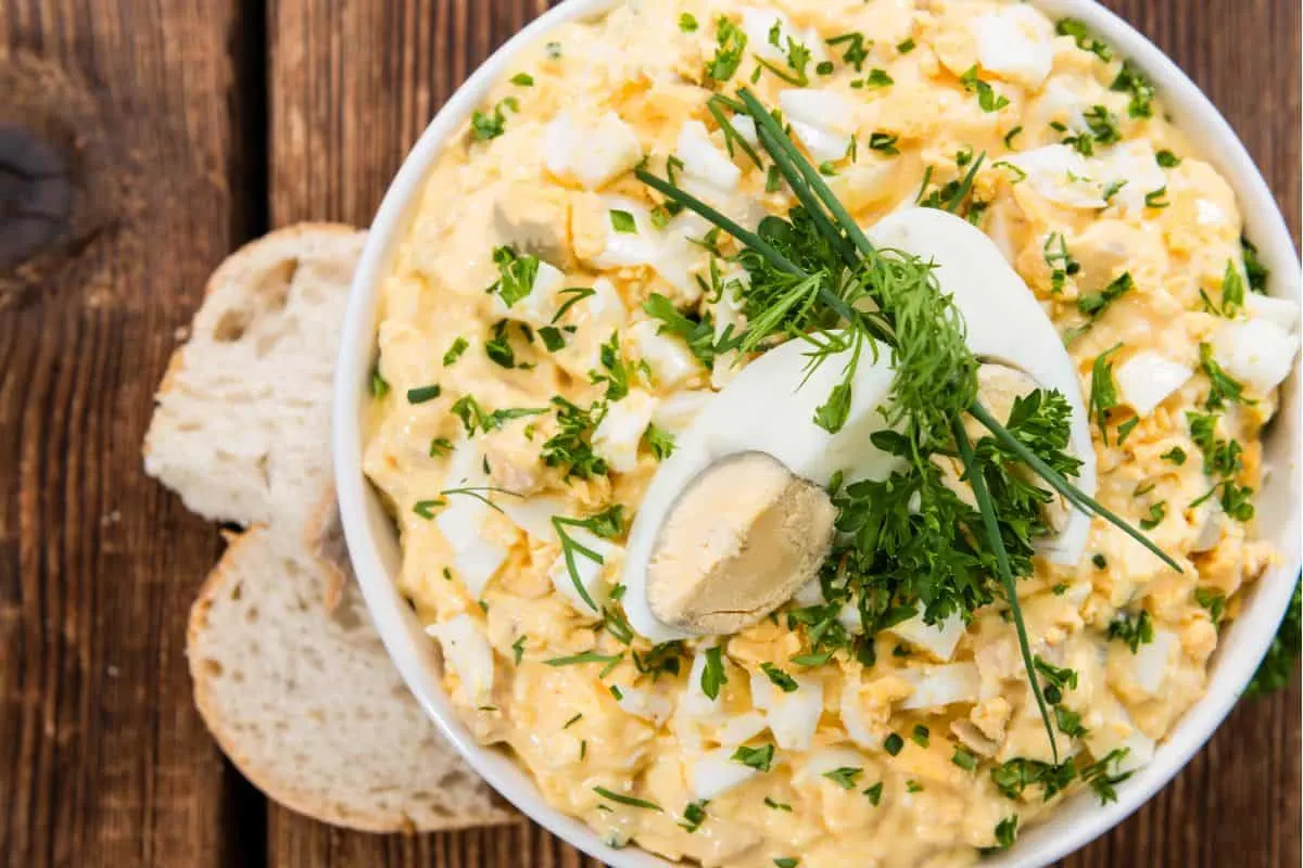 overhead picture of bowl of egg salad with fresh herbs on top