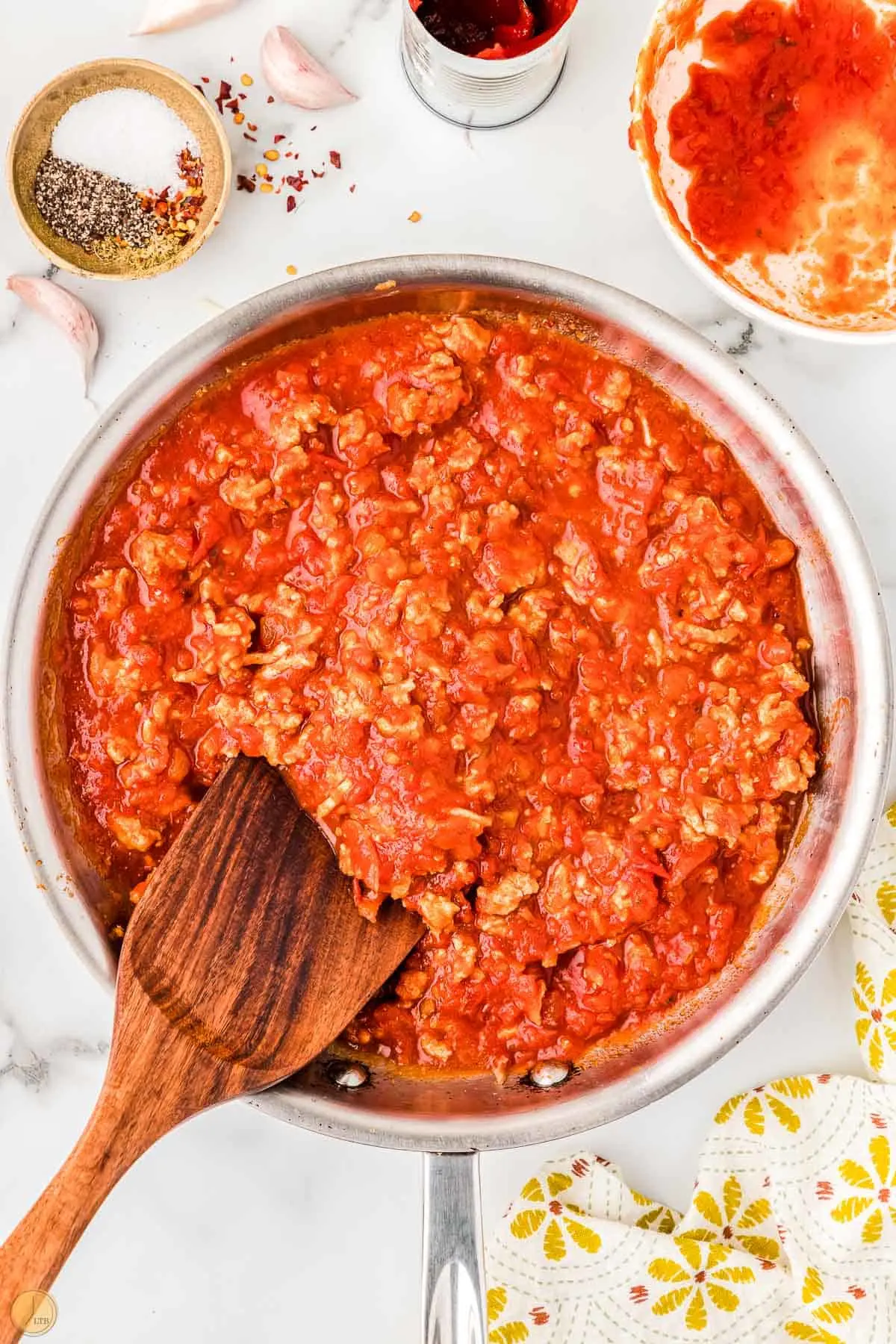 meat sauce in a skillet with a wood spoon