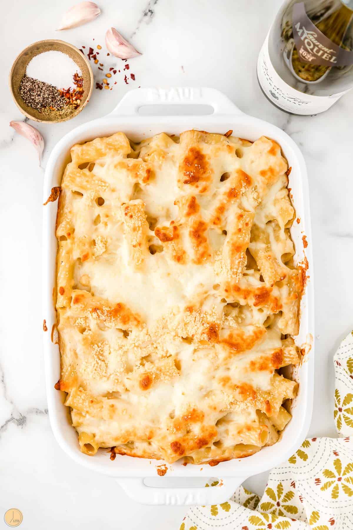 baked cheesy rigatoni noodles in a white dish