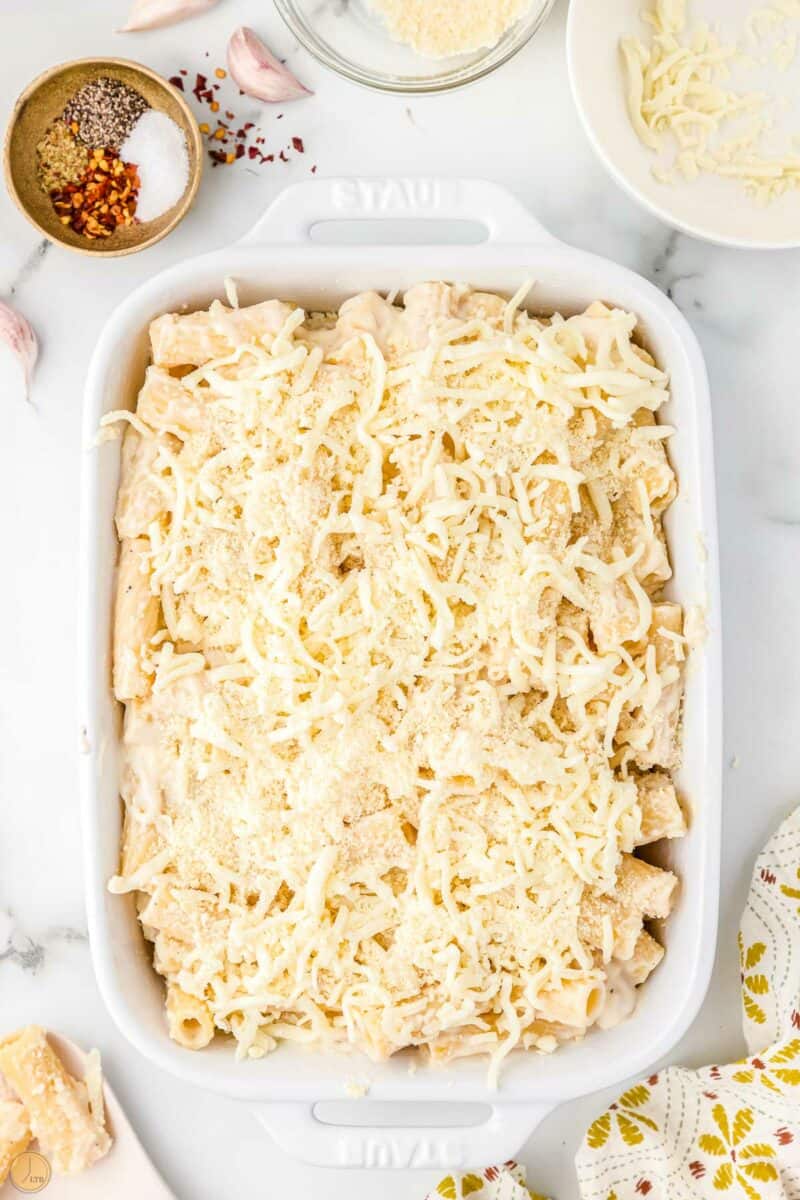 unbaked pasta topped with cheese in a casserole dish