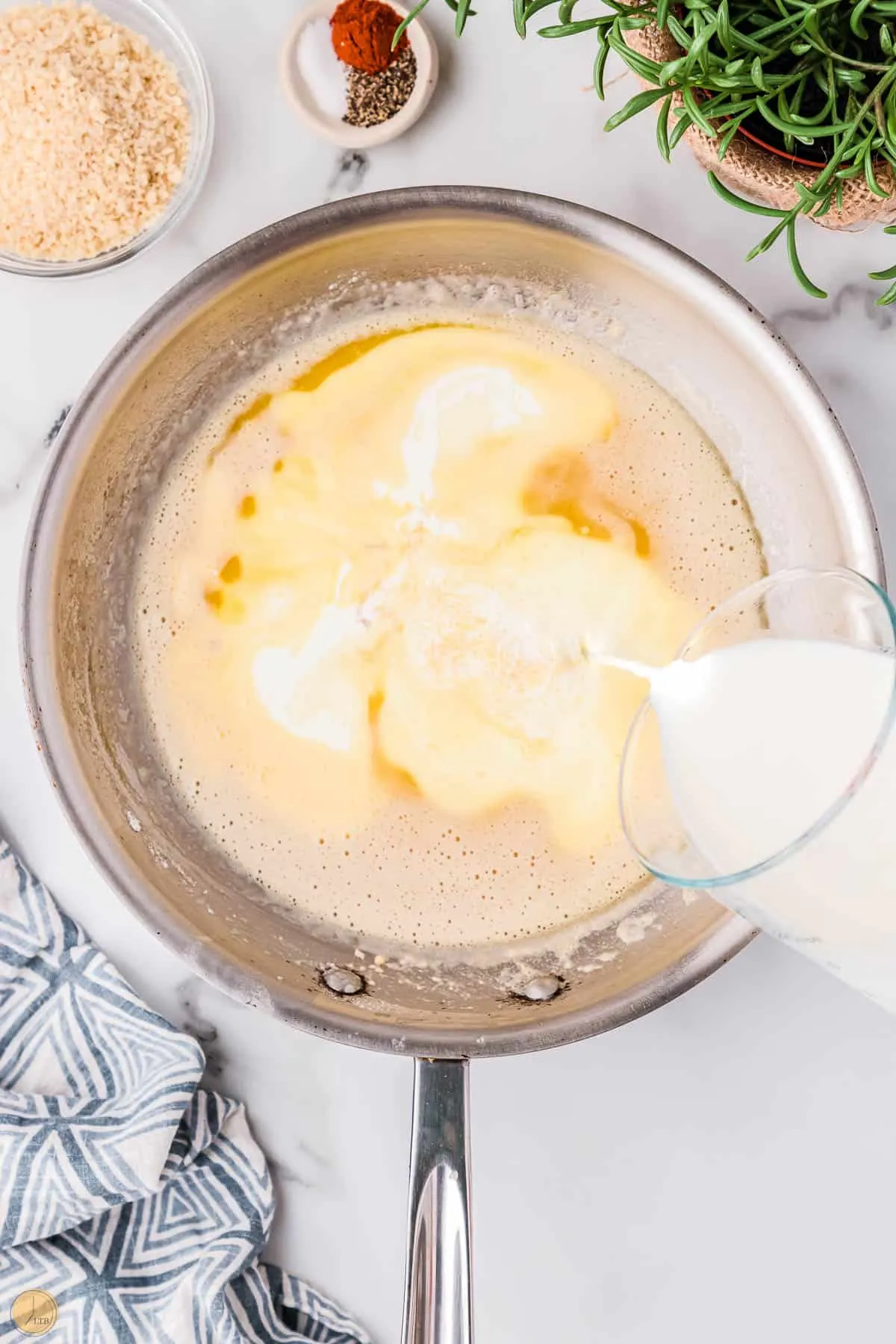 cream pouring into a pan with melted butter