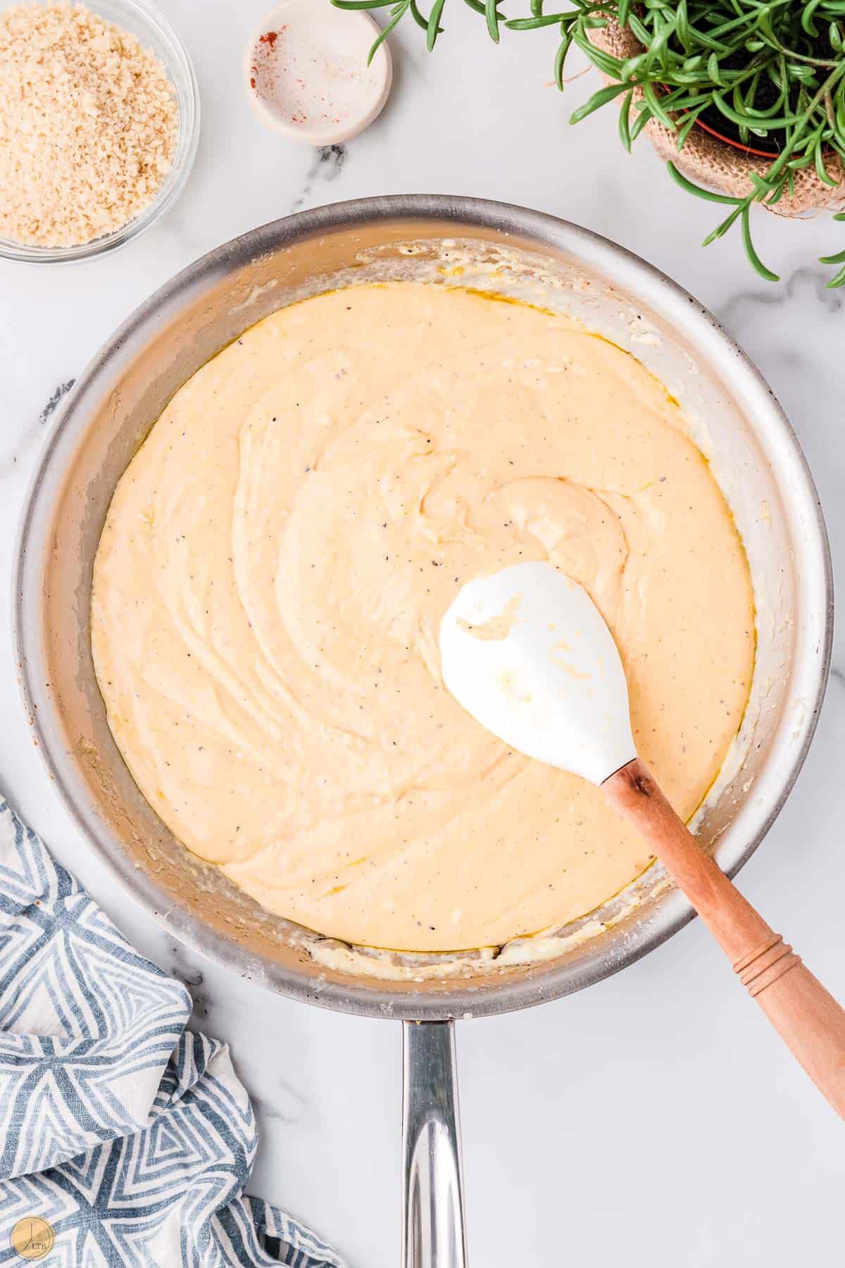 cheese sauce in a pan with a white spatula