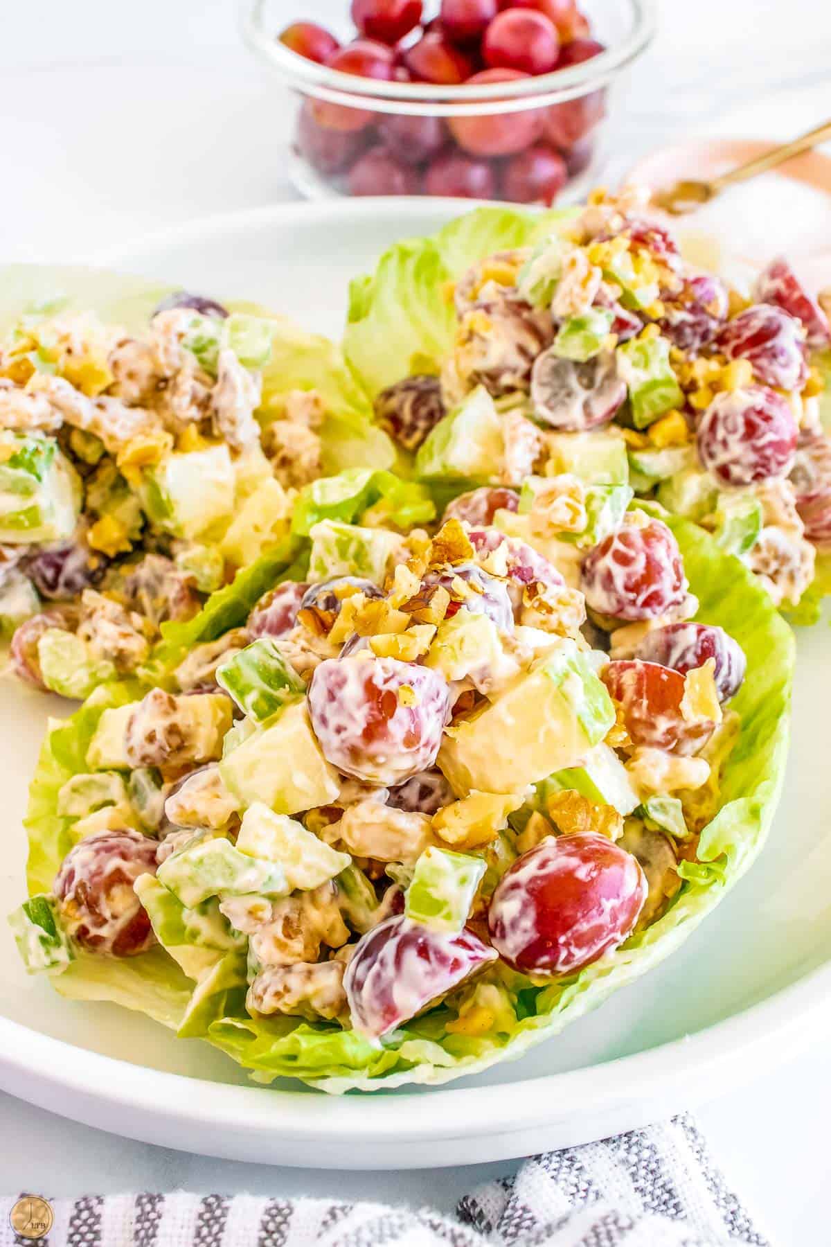 lettuce cups with waldorf salad in it on a plate