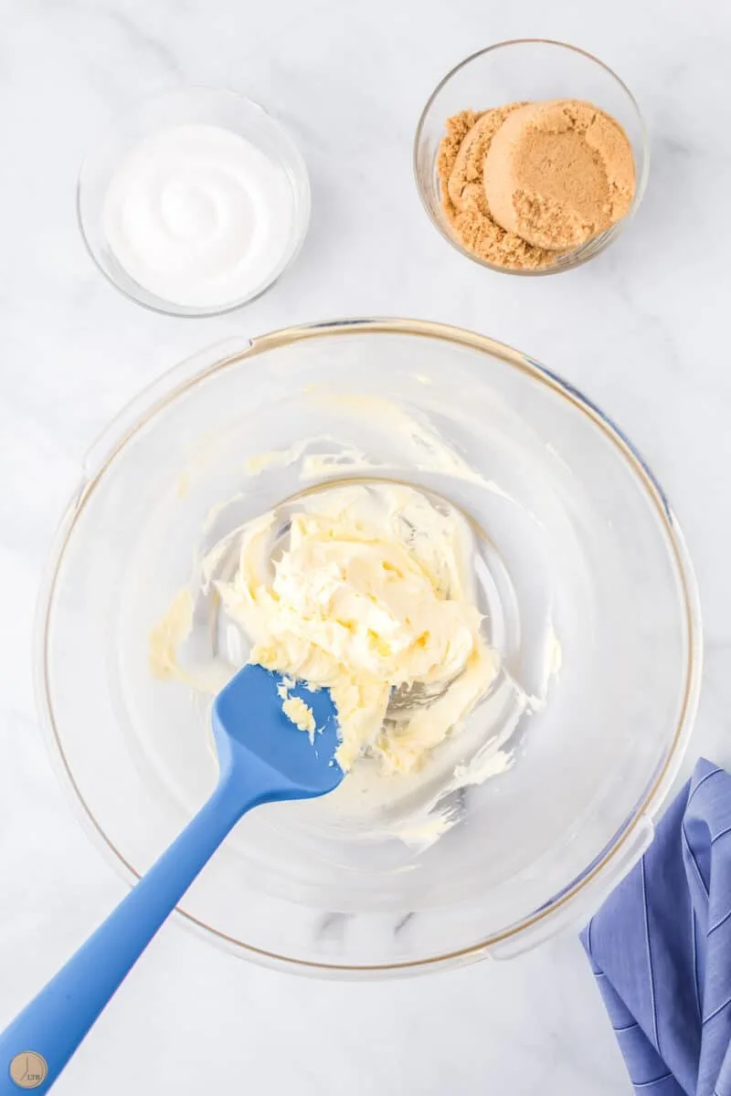 butter creamed in a bowl with a blue spatula
