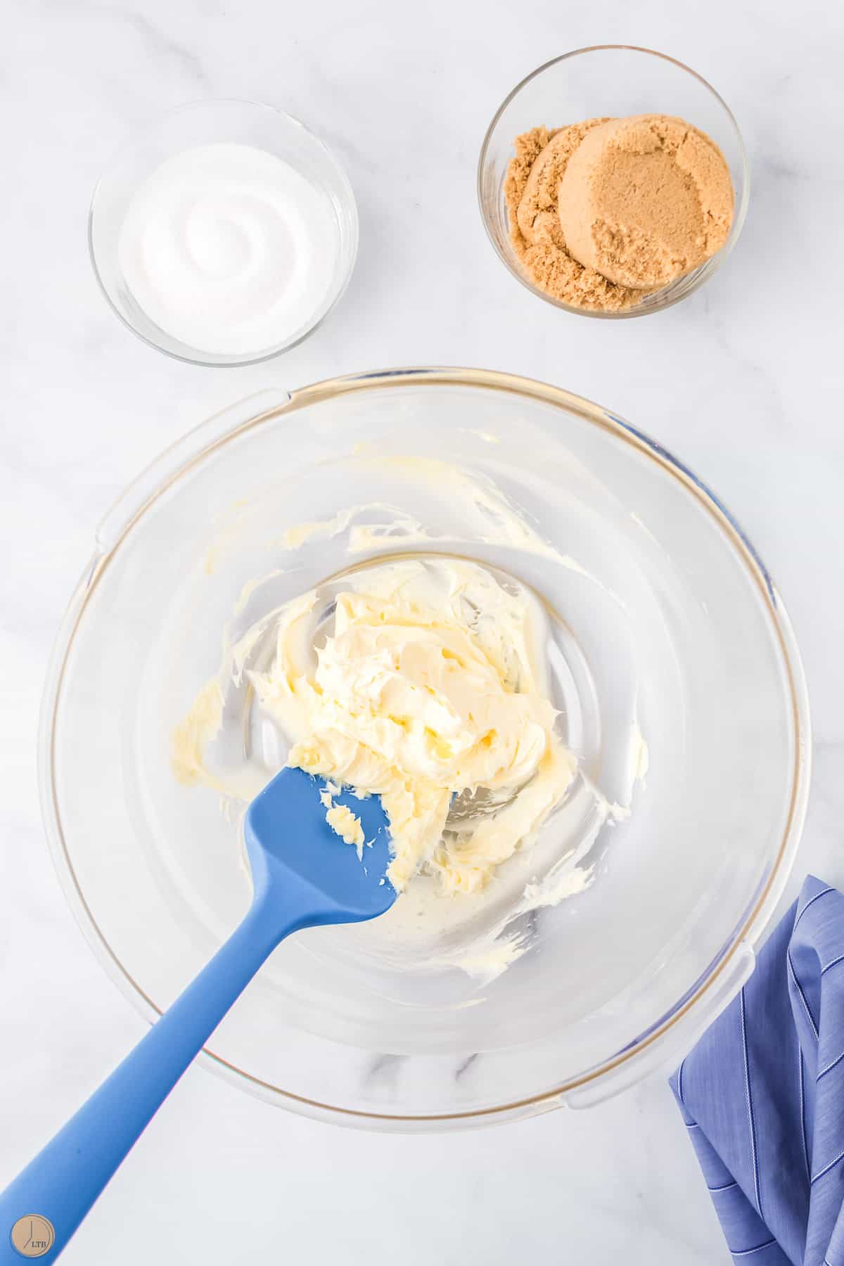 butter creamed in a bowl with a blue spatula