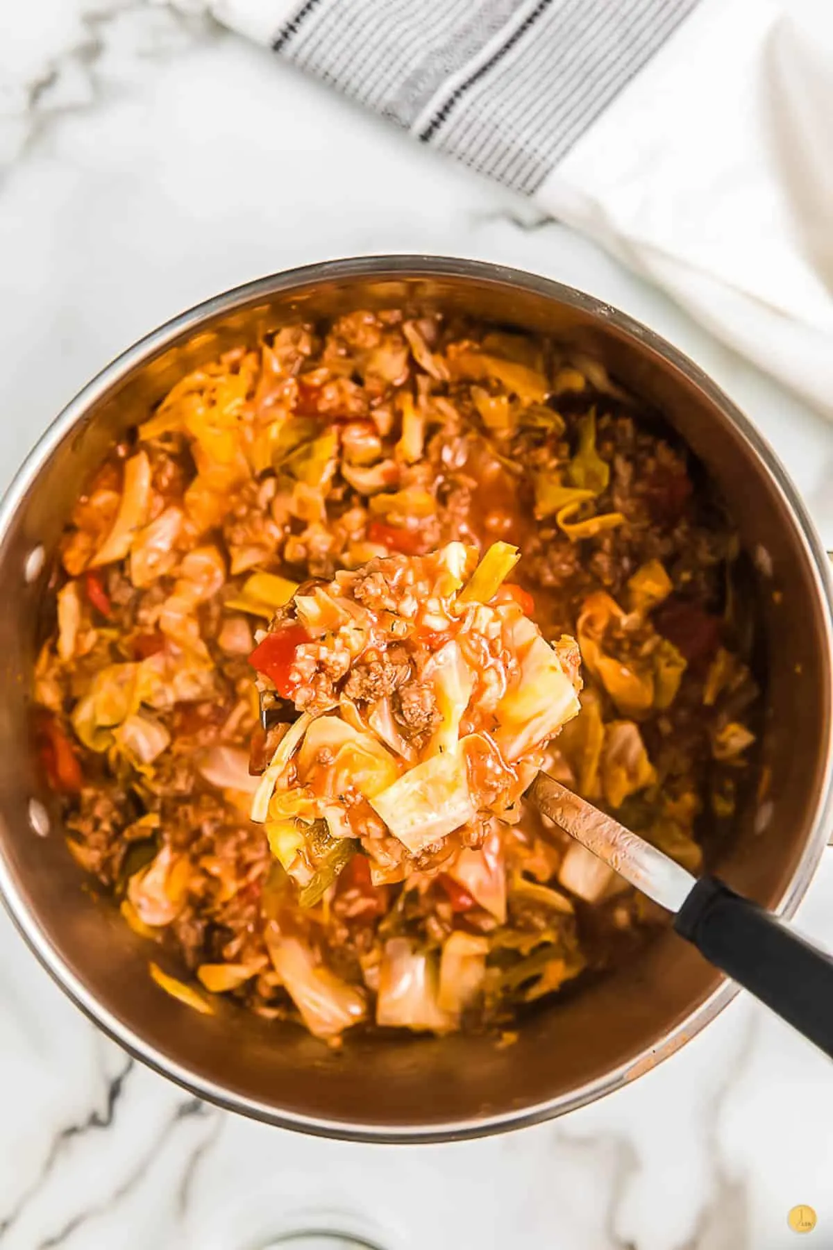white bowl with cabbage soup and spoon