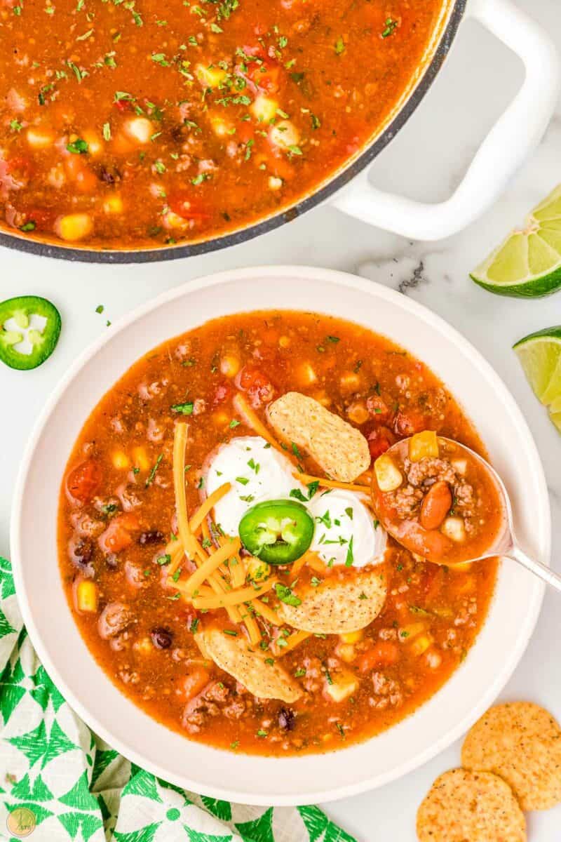 bowl of taco soup with limes and jalapeno
