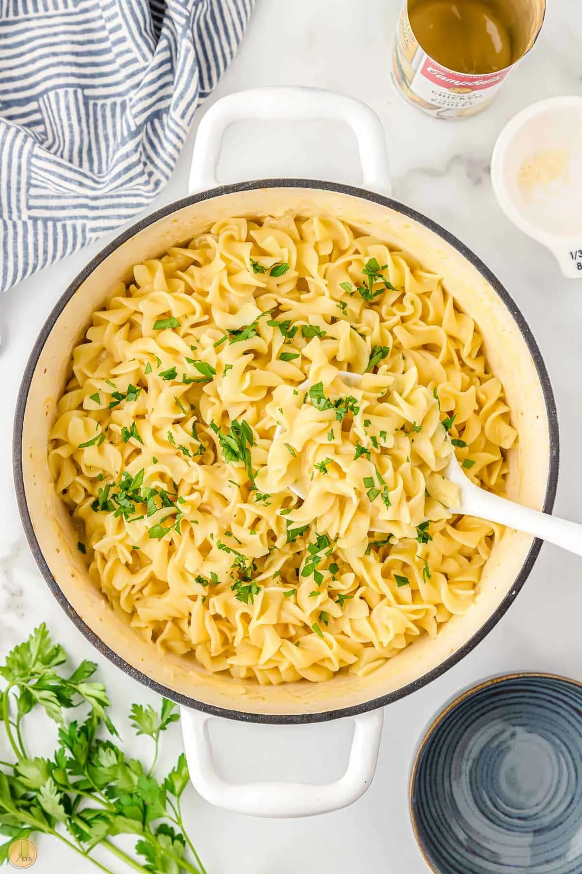 pot of cafeteria noodles in a ladle over a pot