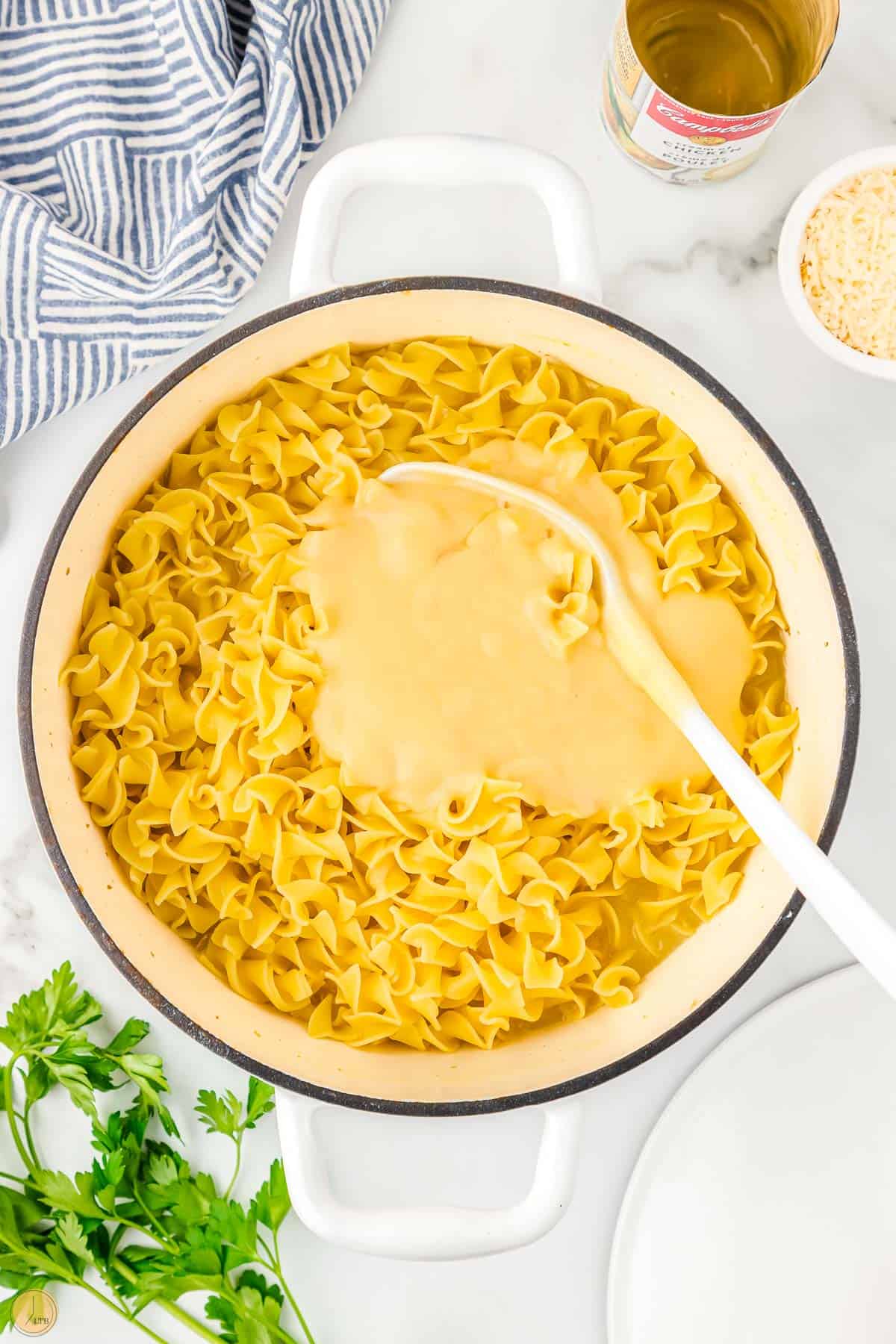 pot of cafeteria noodles over medium heat with spoon