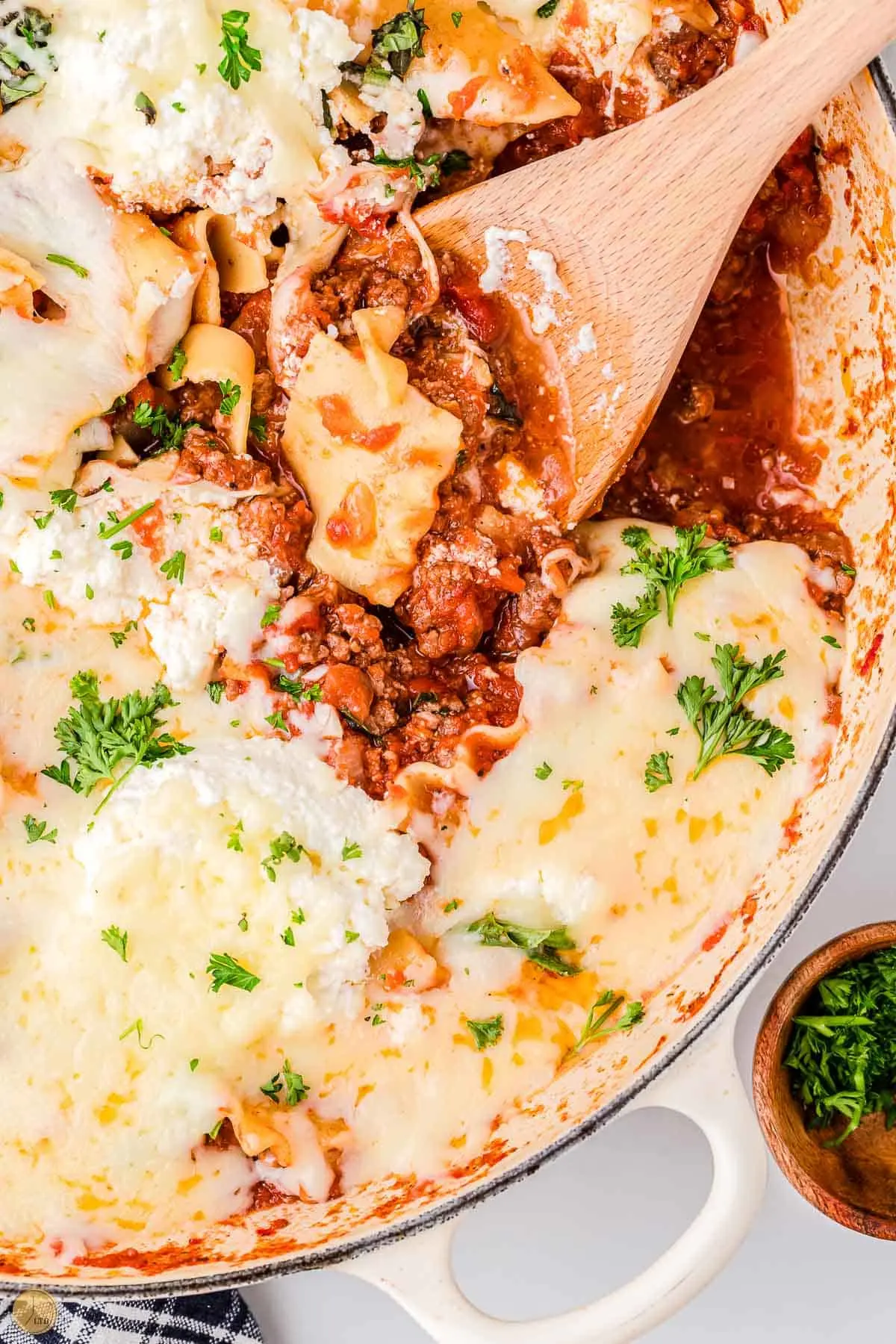 close up of lasagna in a skillet with a spatula