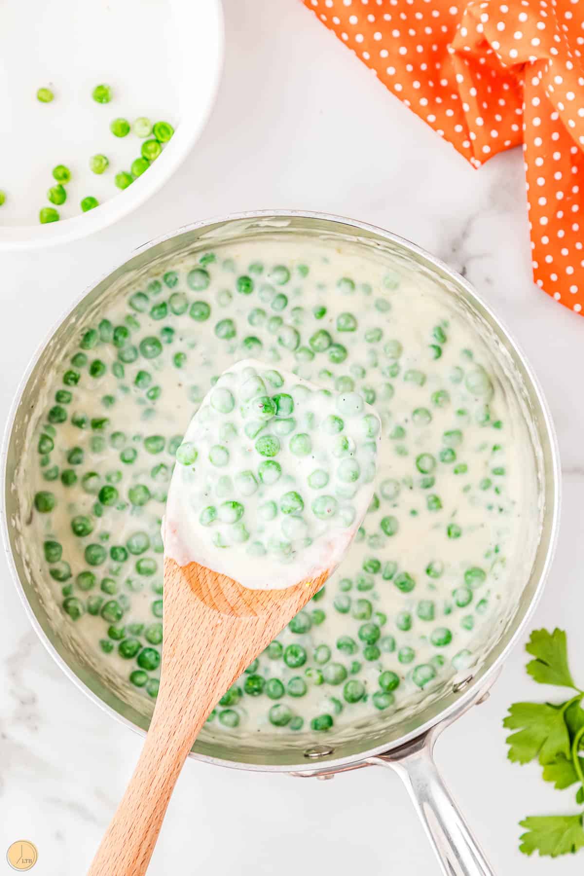 pot of creamed peas with wood spatula