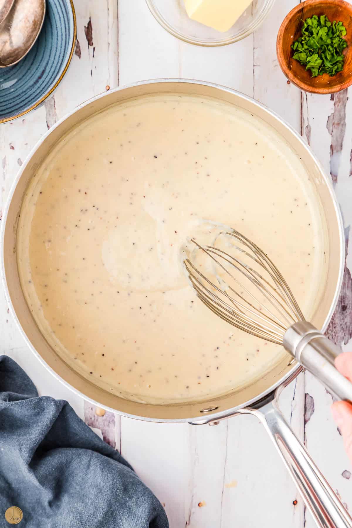 cream sauce in a pot with a whisk