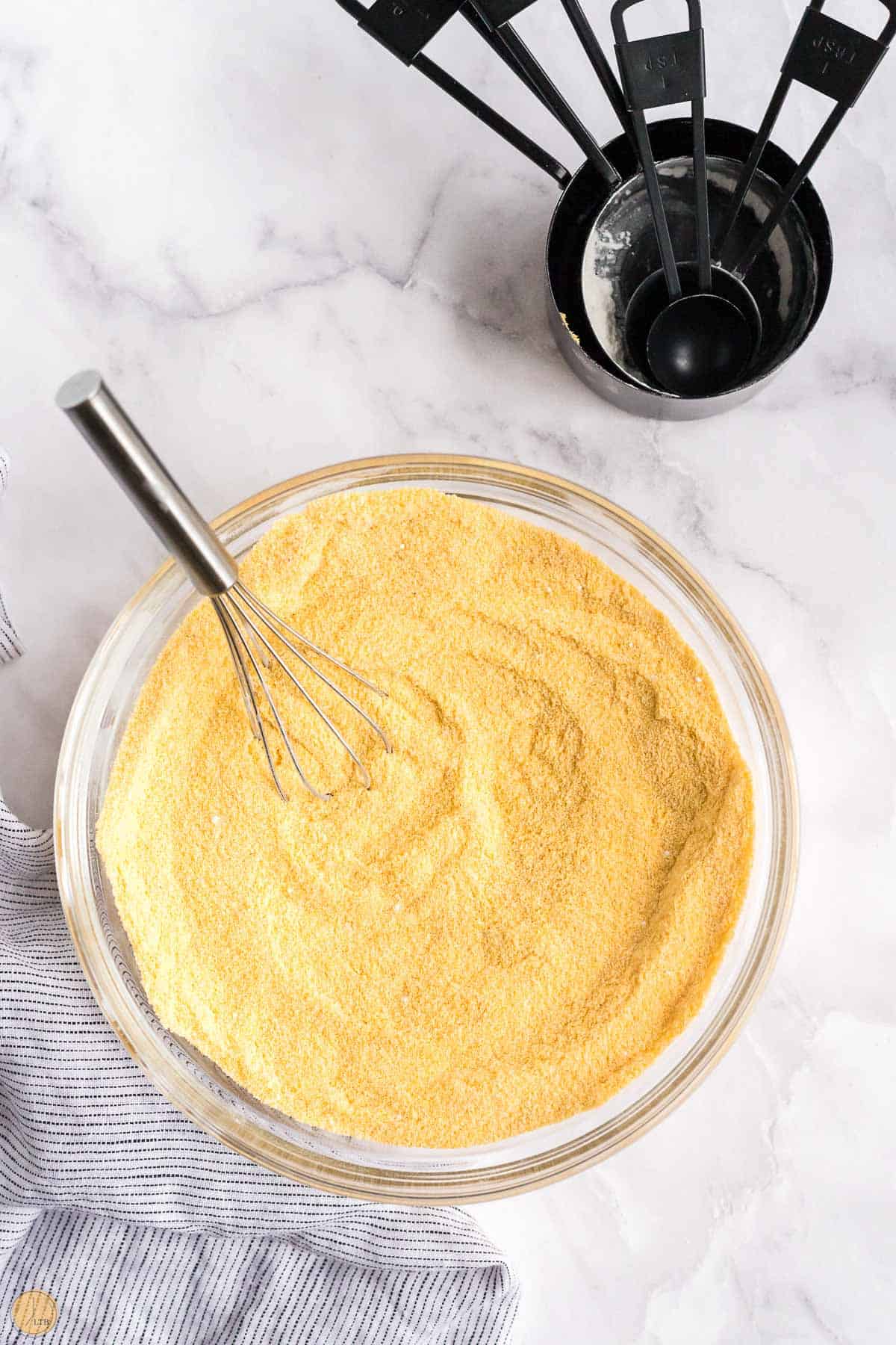 bowl of cornmeal mix with measuring cups