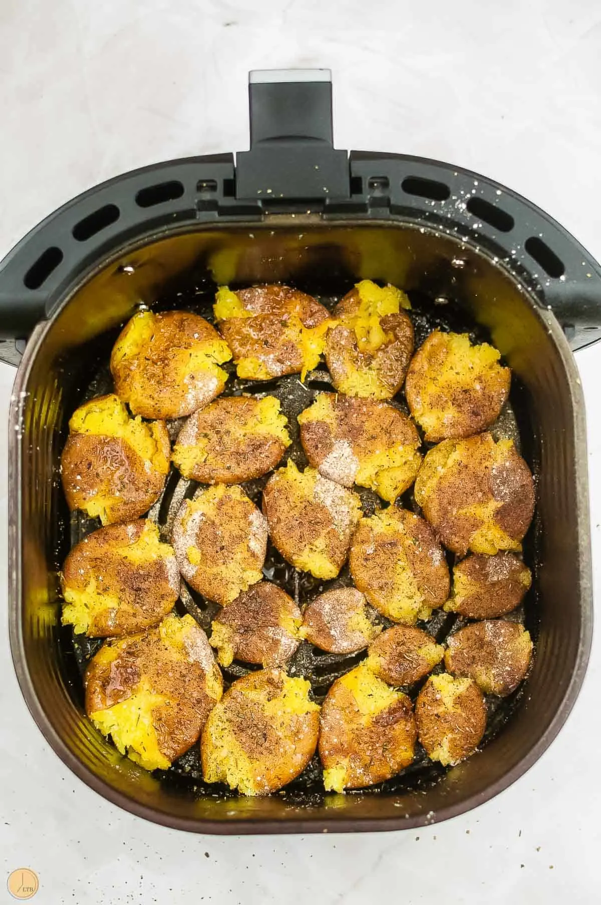 smashed potatoes in an air fryer basket