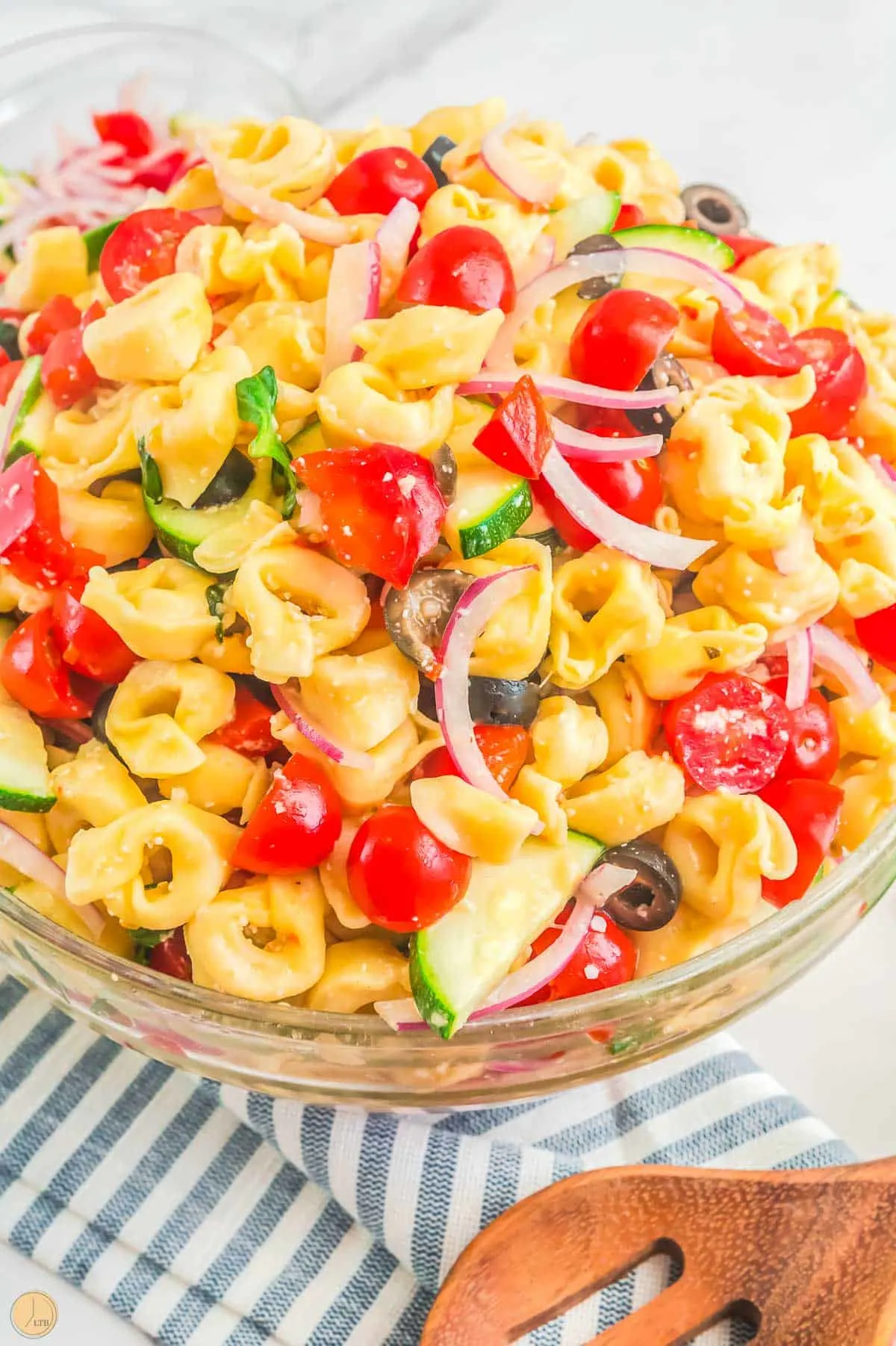 bowl of tortellini pasta salad with wood spoon