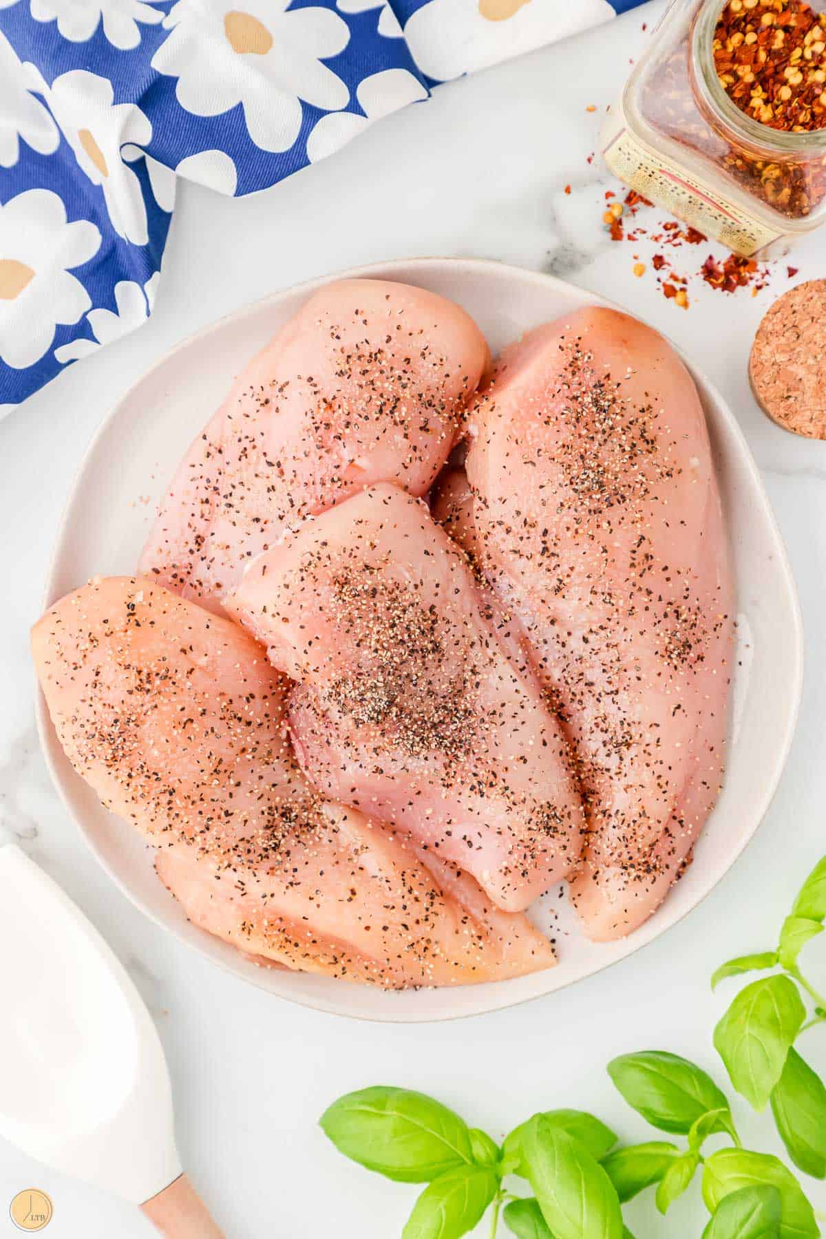 chicken breasts on a pate with salt and pepper
