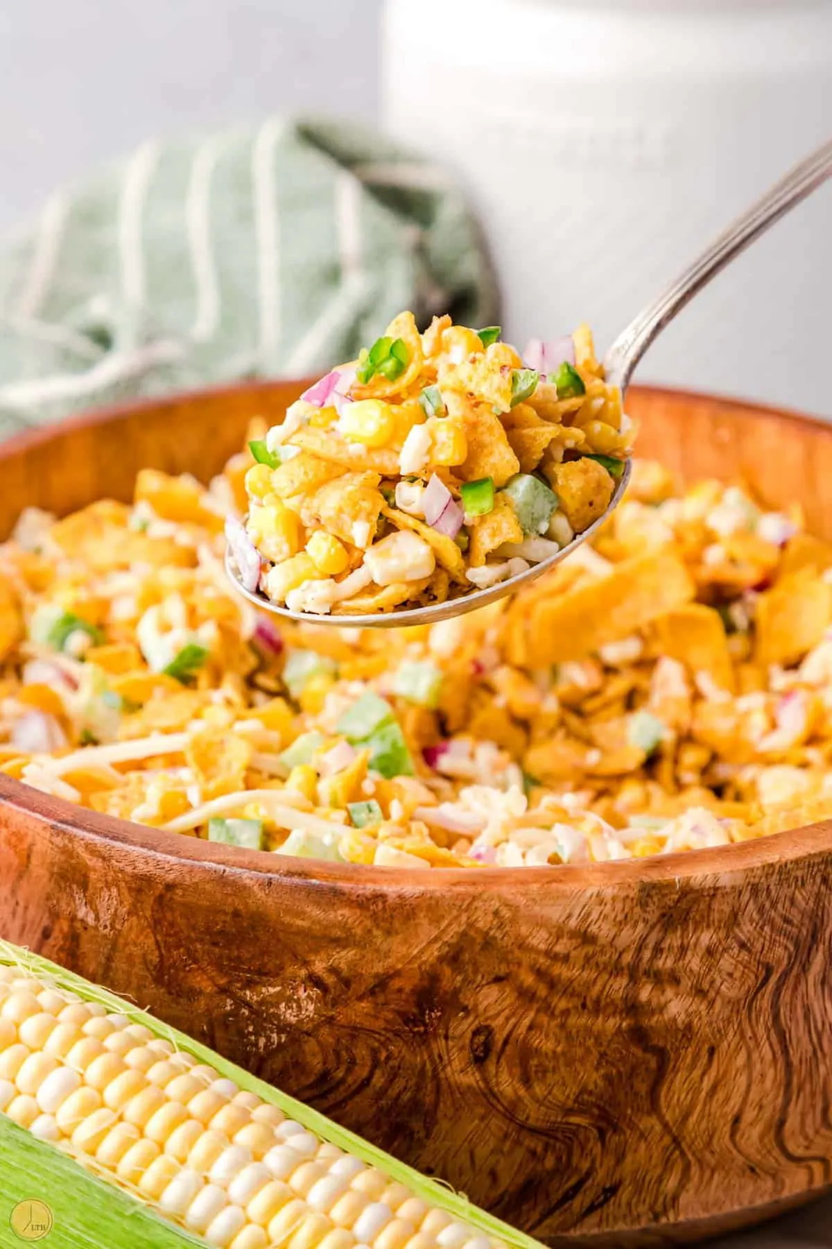 a delicious salad in a spoon above a wood bowl