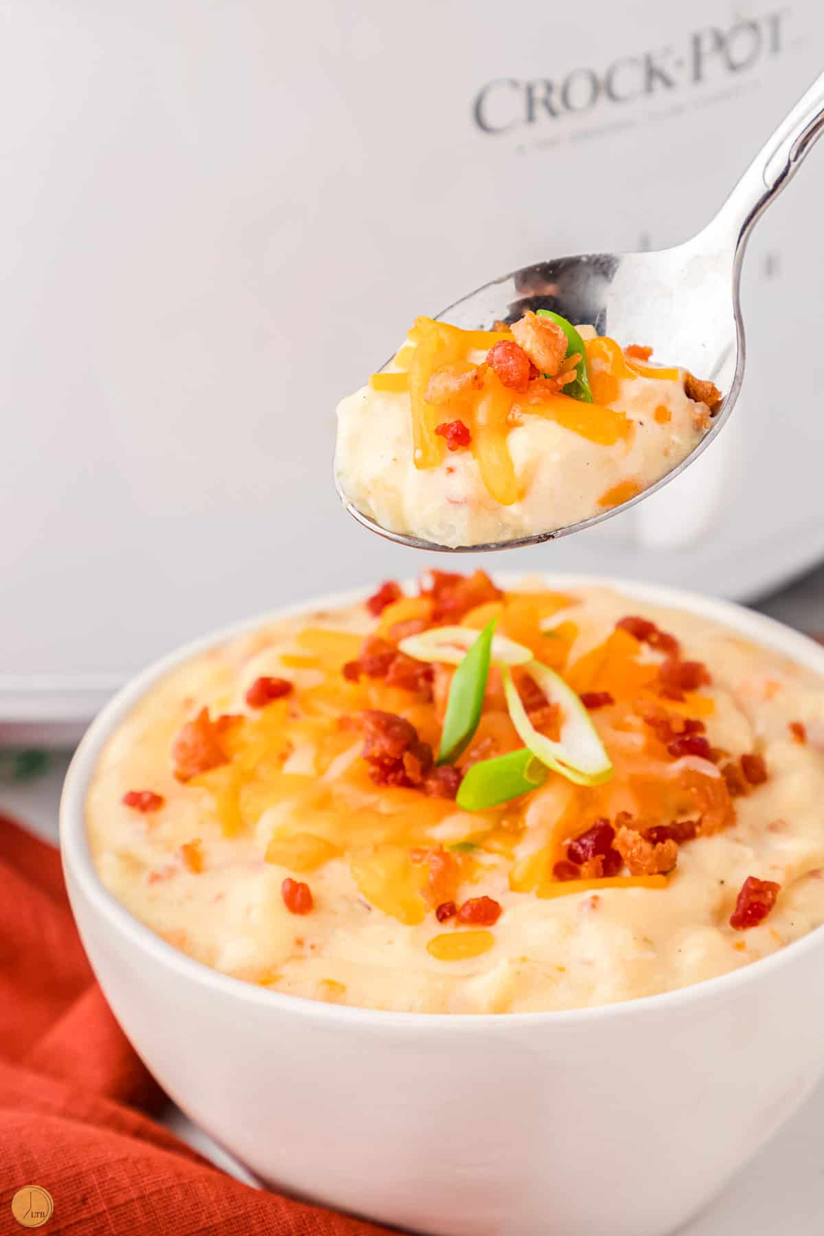 crack potatoes in a soup topped with bacon and cheese